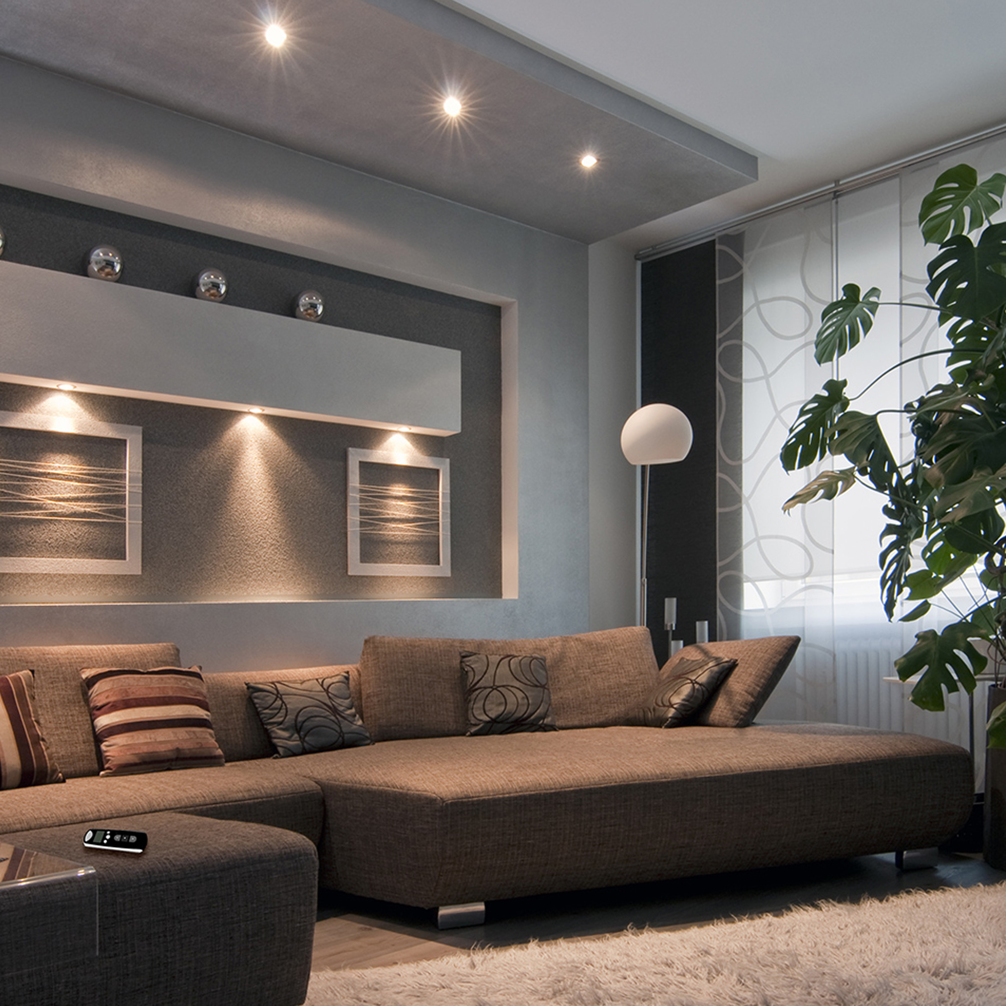 Wohnzimmer mit Sofa, Stehlampe, Wanddekoration und Pflanzen im modernen Design