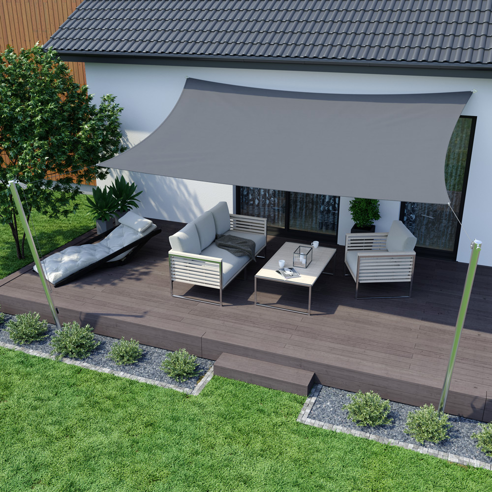 Dreieckiges Sonnensegel über Terrasse mit Sitzgruppe und Tisch