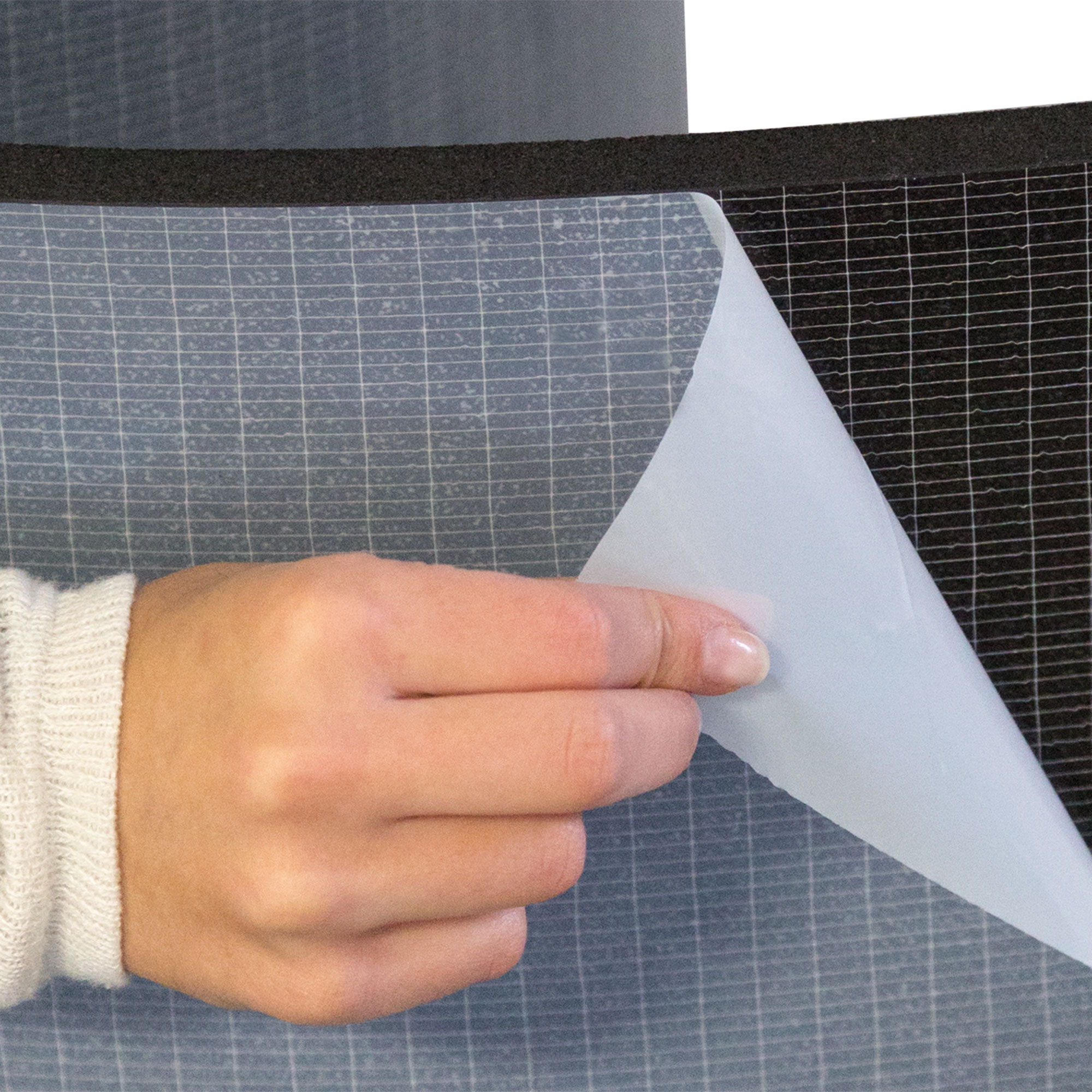 slider_image_68fb59b19ff14eedb652cb189ad71502 Hand zieht Schutzfolie von einer strukturierten Oberfläche ab