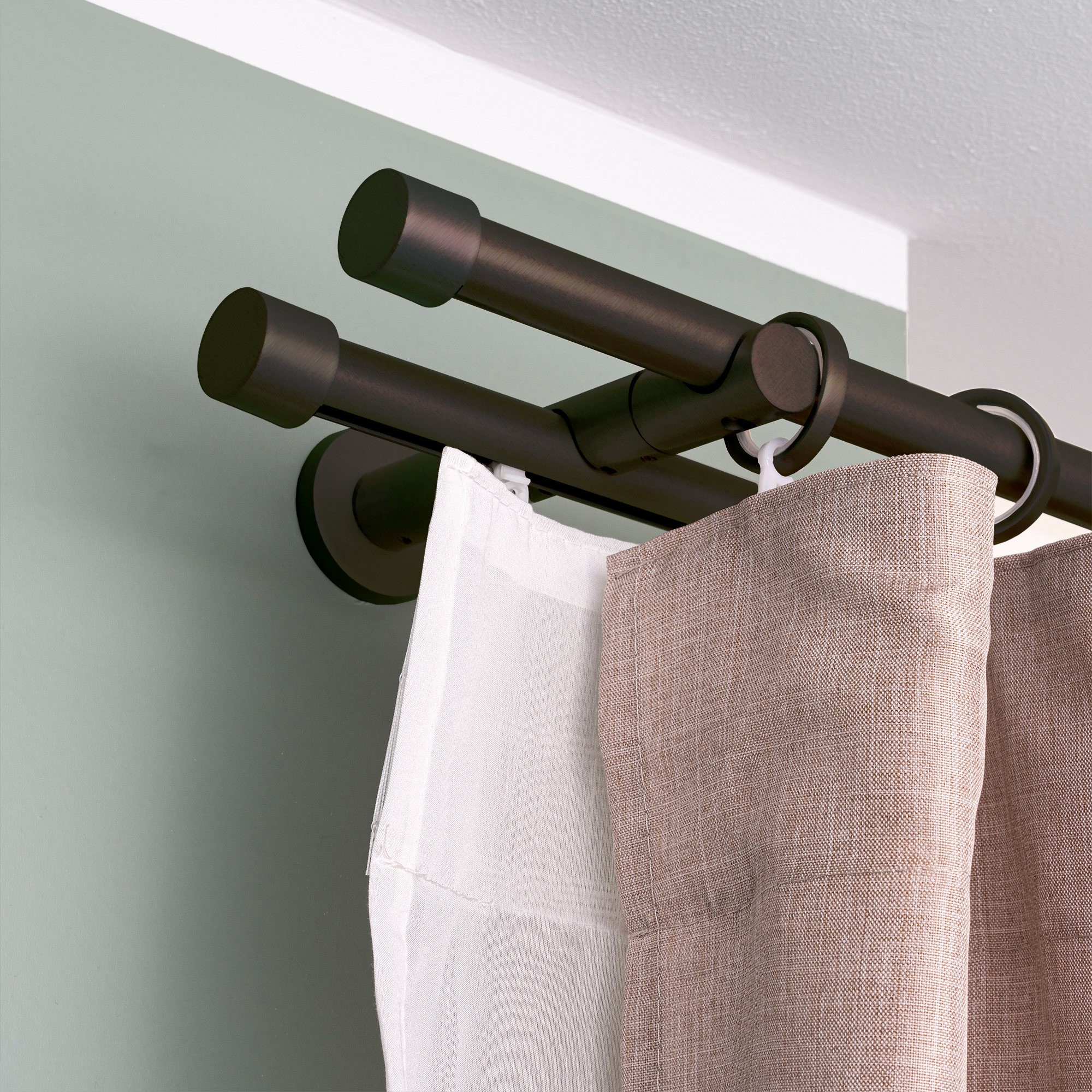 Gardinenstange mit Innenlauf und montierten Vorhängen an der Wand befestigt