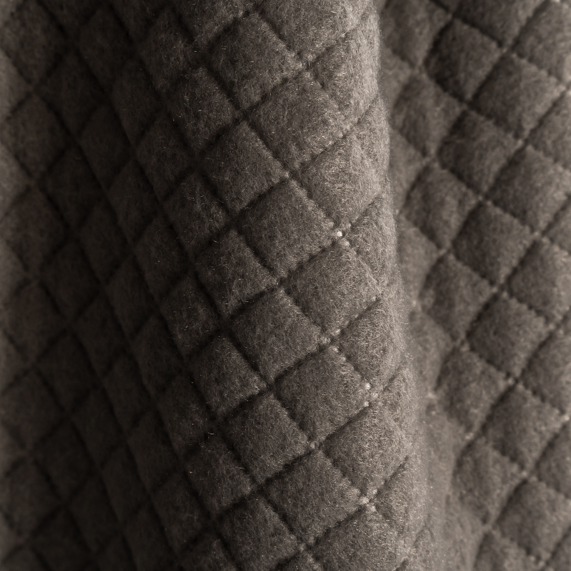 slider_image_019228cb19827137924ca3aabf361156 Gesteppter Stoff mit rautenförmigem Muster in Nahaufnahme