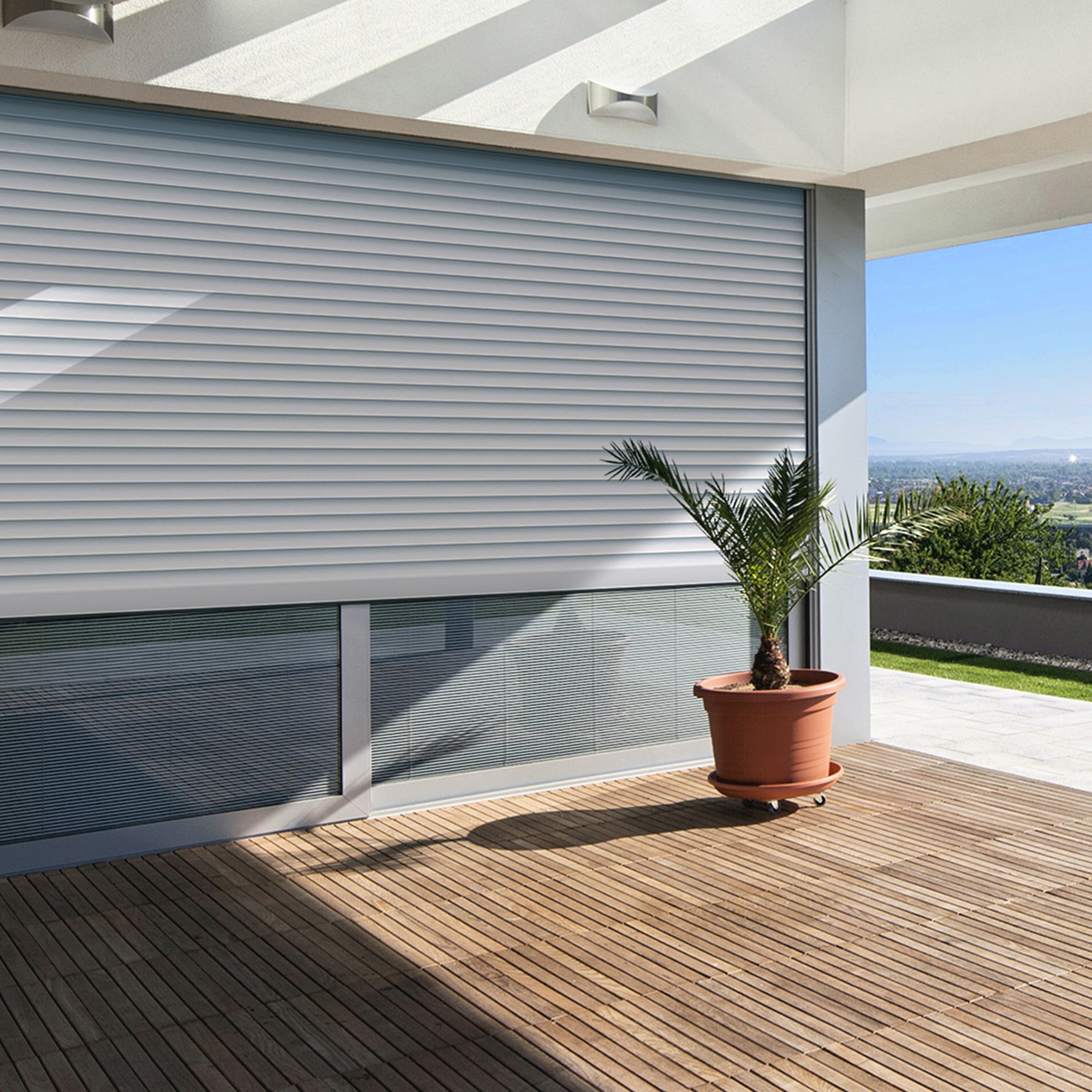 slider_image_0193787159637def8fa542064103f31c Rollladen mit Dämmung an einem Fenster, Terrasse mit Pflanze im Vordergrund