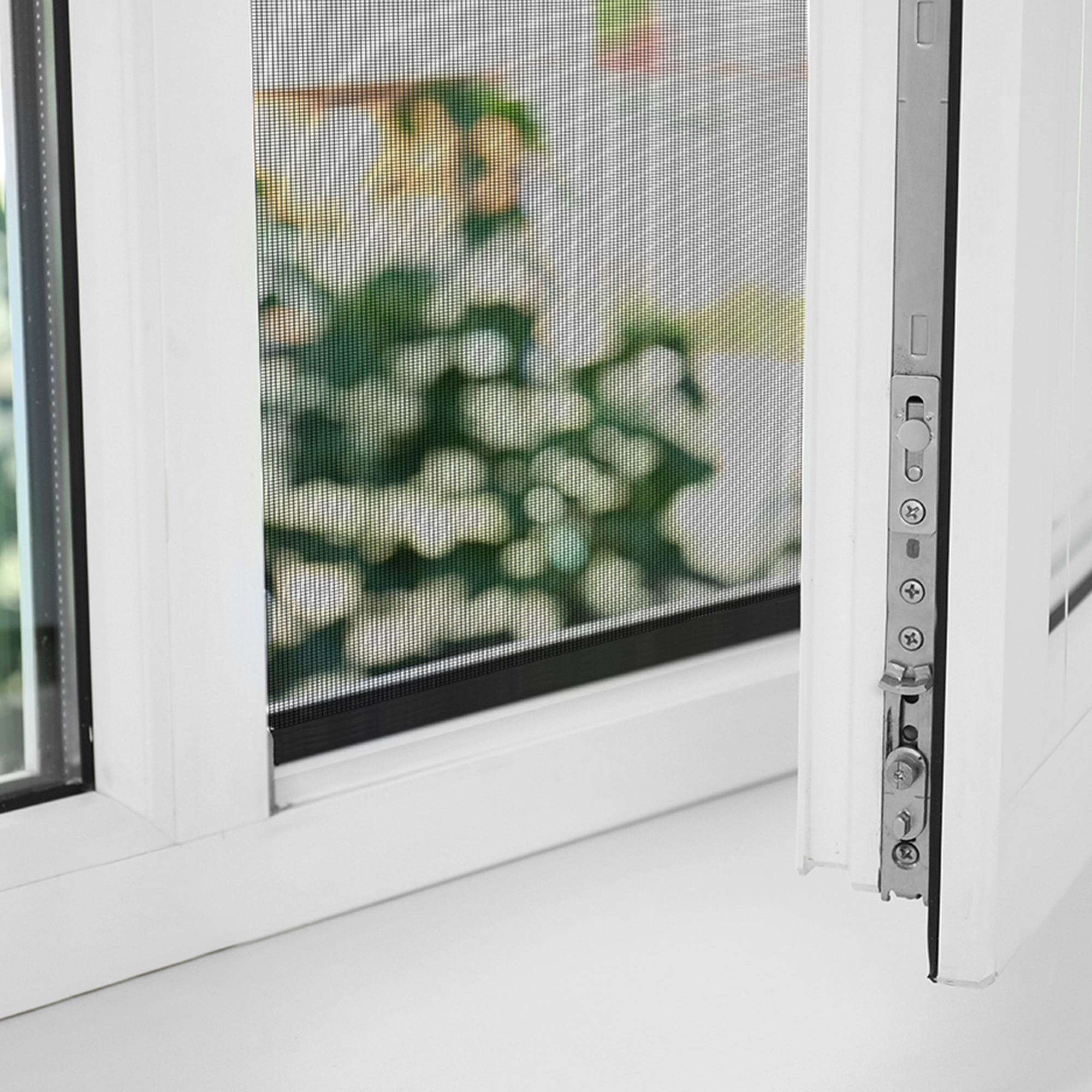 Offenes Fenster mit integriertem Insektenschutzgitter und sichtbarem Schließmechanismus