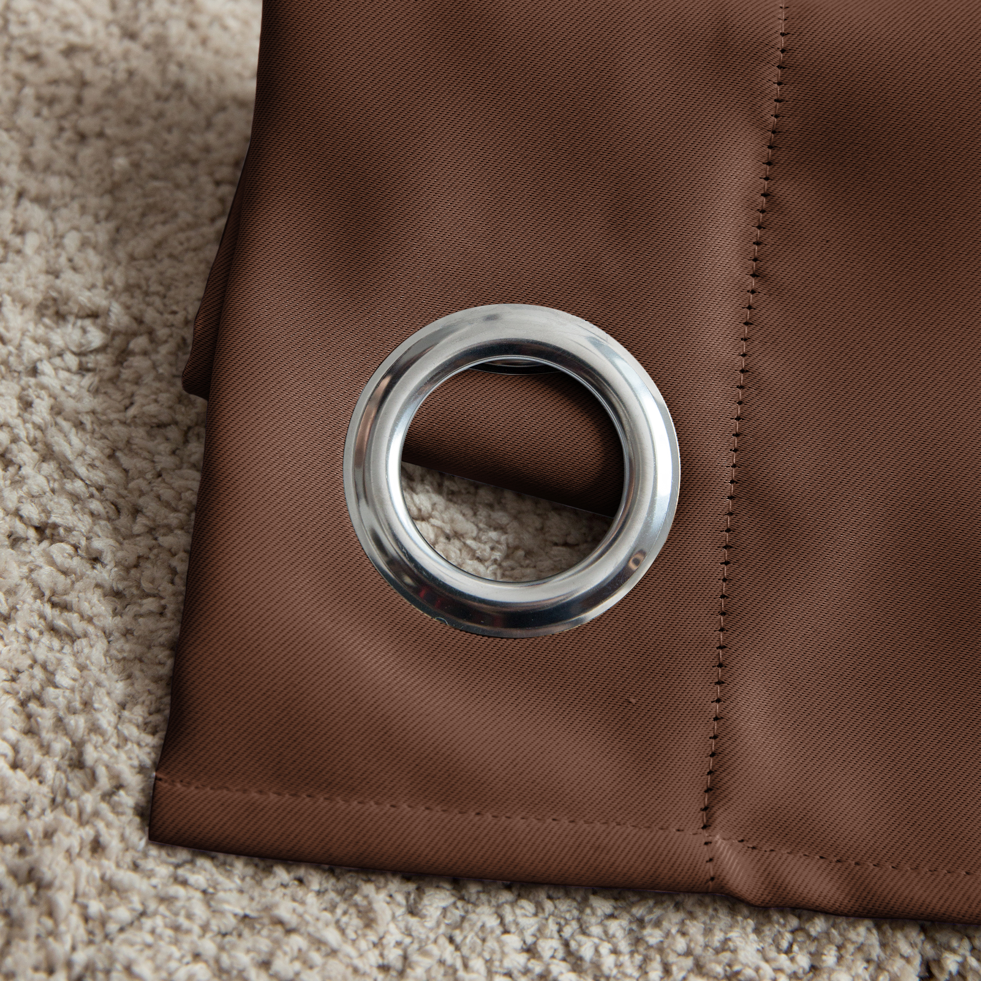 slider_image_c3b2a7f9cb504f25b510f895d53a1111 Ösenvorhang mit Metallring auf Teppich liegend