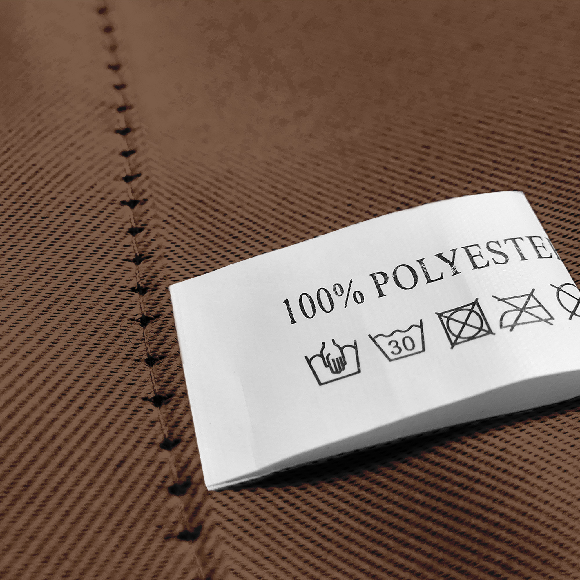 Nahaufnahme eines Stoffes mit Öse und Pflegeetikett aus 100% Polyester