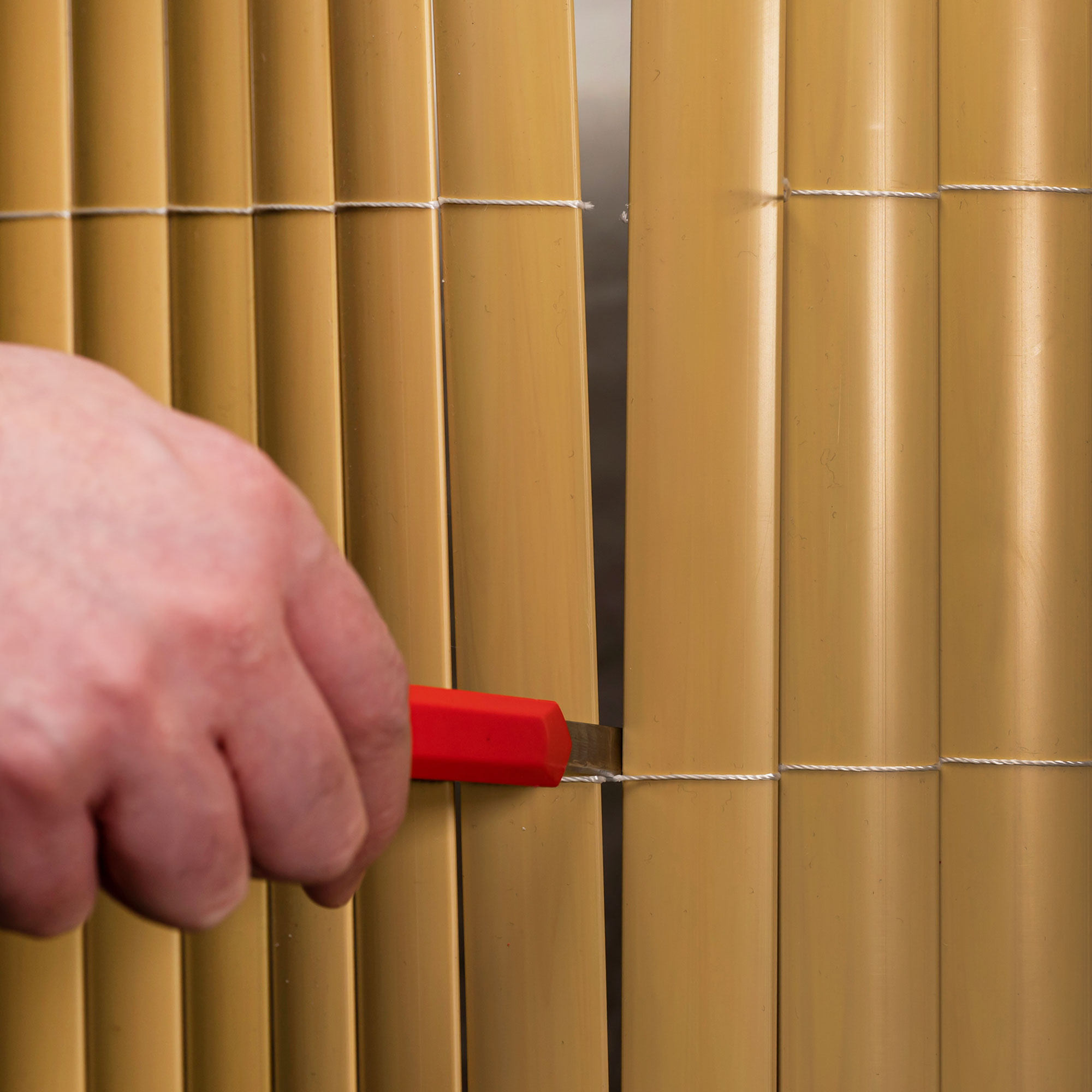 slider_image_35ccbc743ea74519a70d3edf3fee4936 Hand schneidet PVC Sichtschutzmatte mit Messer