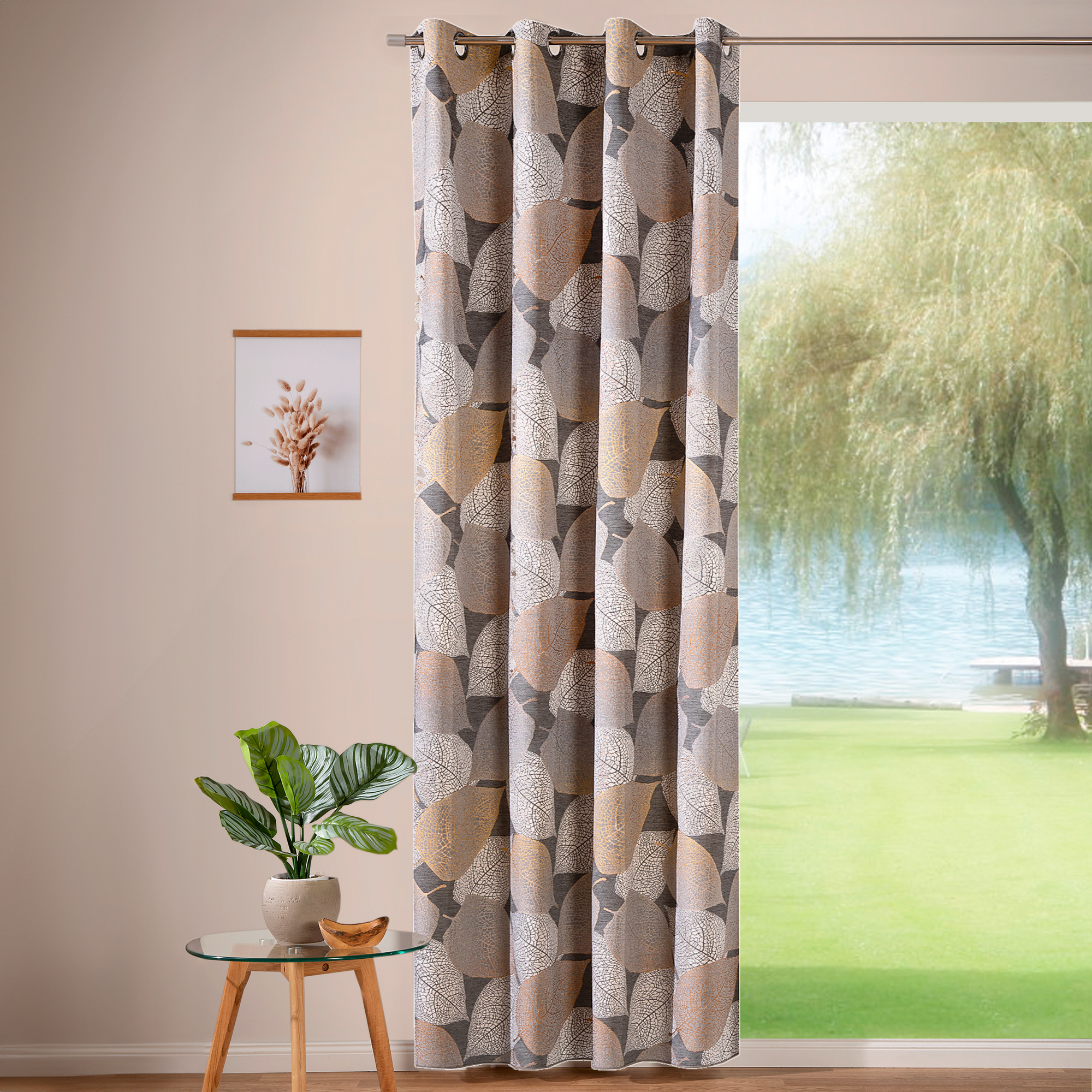 Ösenvorhang mit Blattmuster vor einem Fenster mit Blick auf einen Garten und See