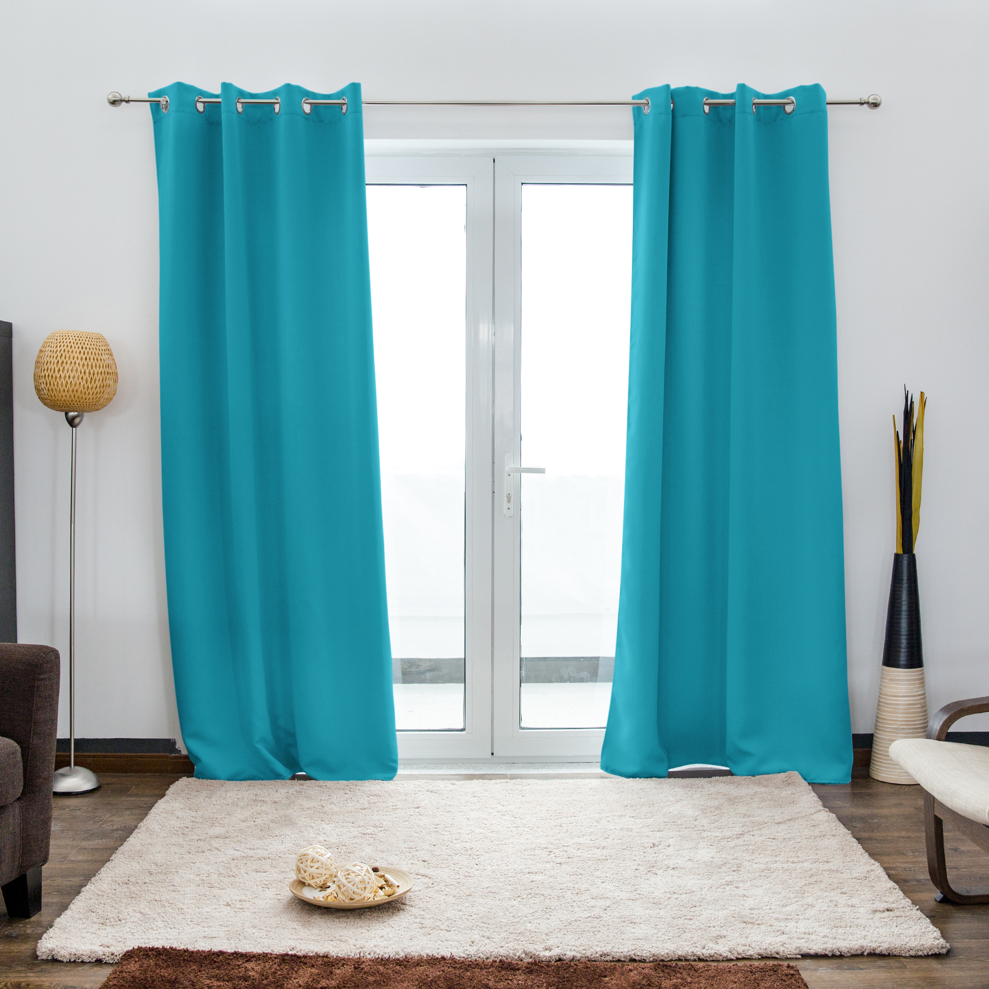 Ösenvorhang vor einer Glastür in einem Wohnzimmer mit Teppich und Stehlampe