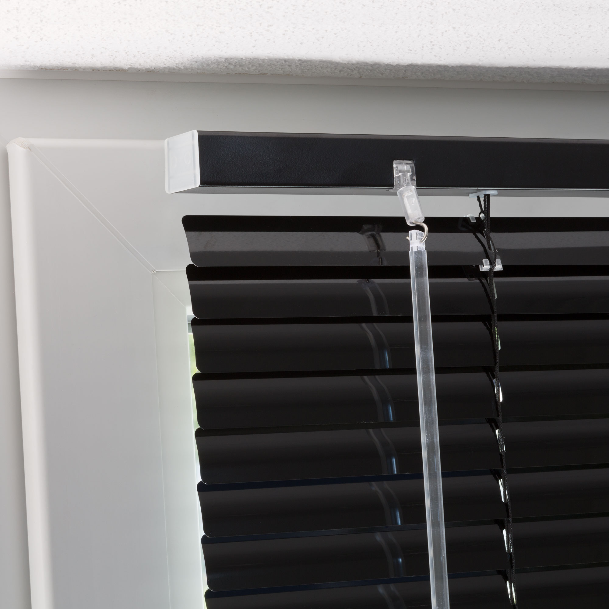 Aluminiumjalousie an einem Fenster mit verstellbaren Lamellen und Zugmechanismus