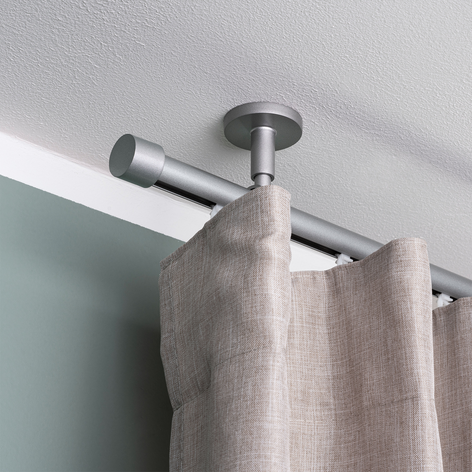 Gardinenstange mit Innenlauf und montiertem Vorhang an der Decke befestigt