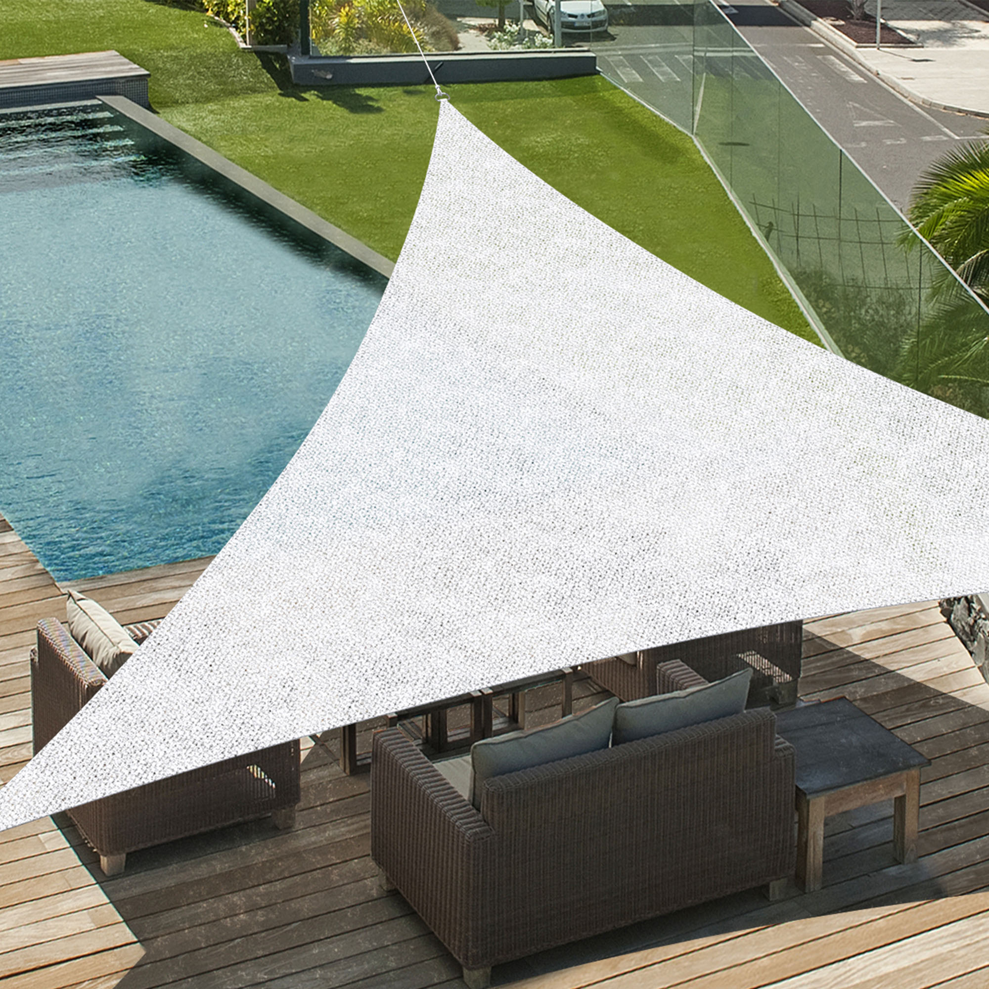 Dreieckiges Sonnensegel über Terrasse mit Sitzmöbeln und Pool im Hintergrund