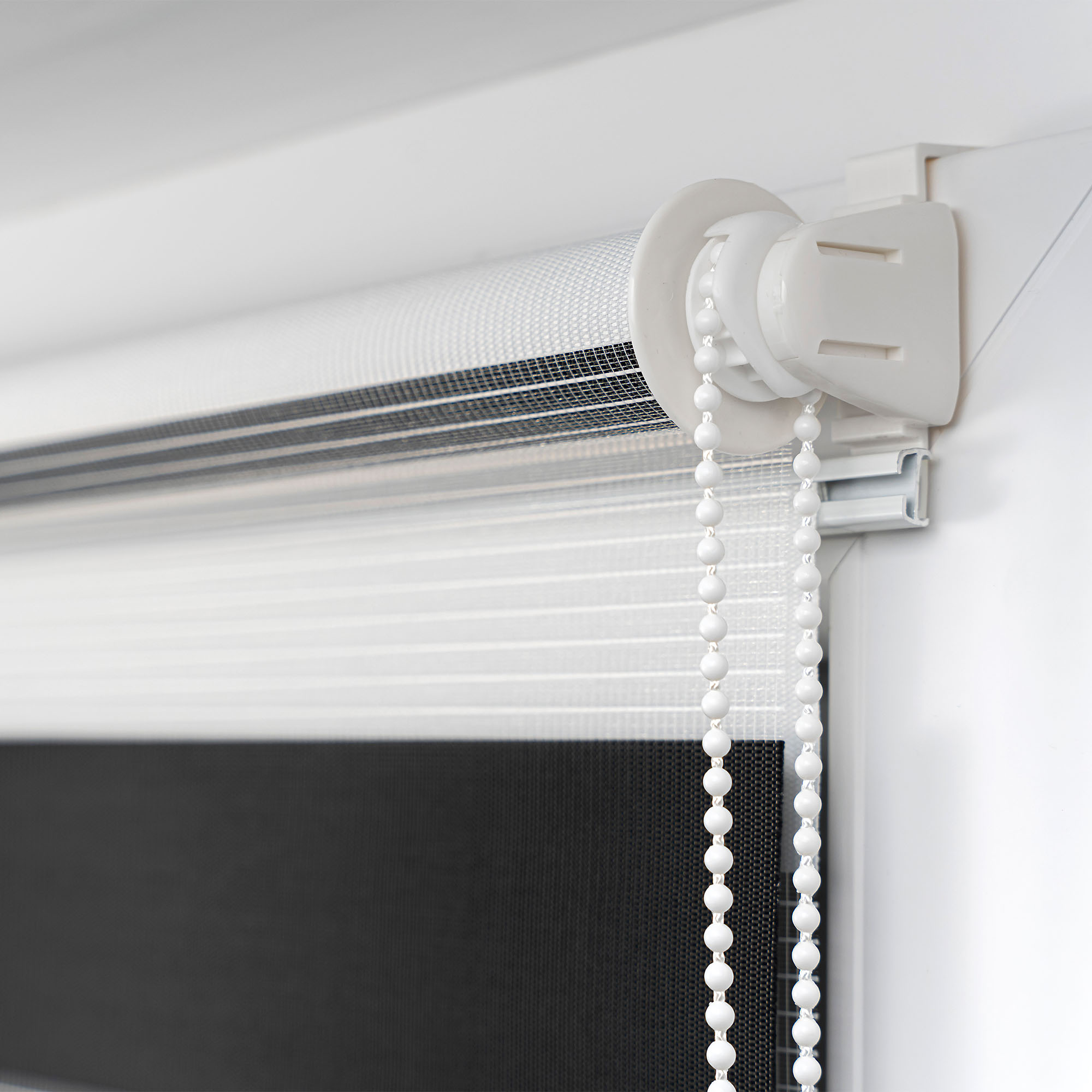 slider_image_26009e1c761c4341a19cfd76a62e3af8 Klemmfix Doppelrollo mit Kettenzug zur Lichtregulierung an einem Fensterrahmen montiert