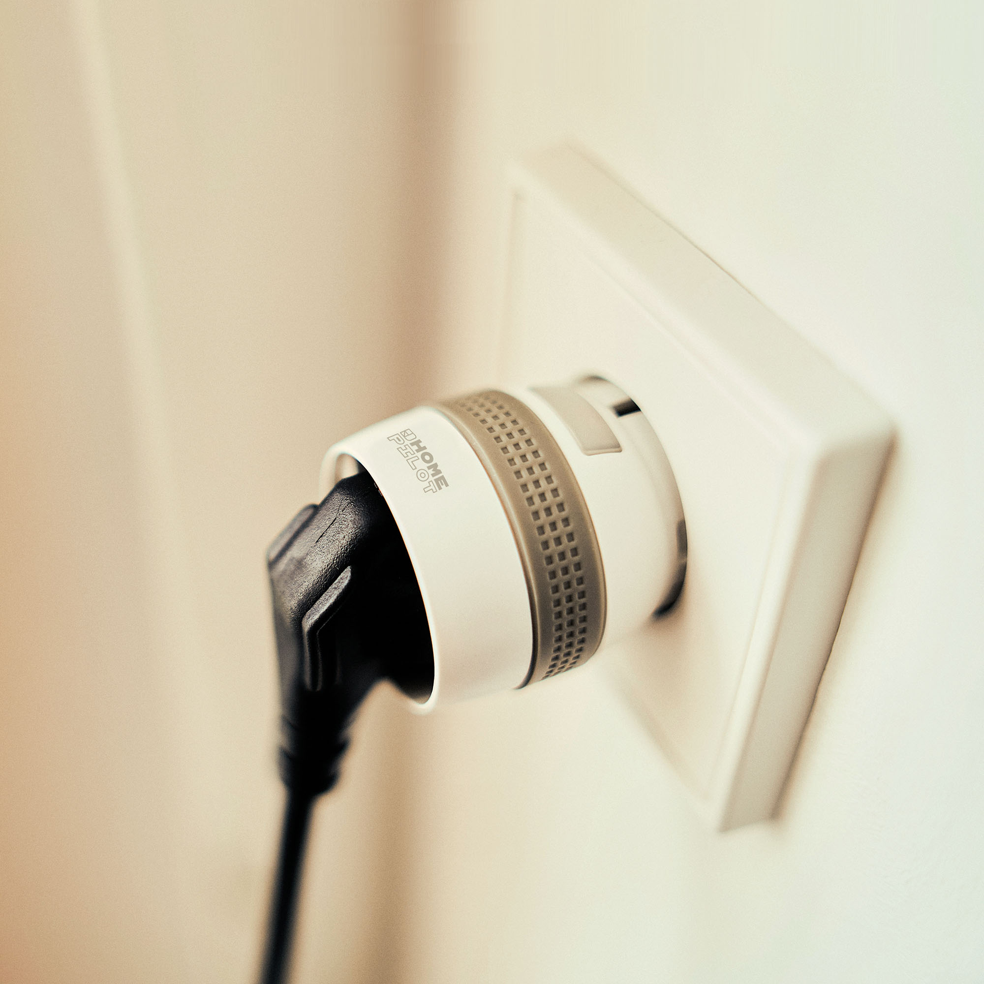 slider_image_0192756604207a6899406e73eacde80d Smart-Zwischenstecker in Steckdose mit eingestecktem Kabel, zeigt smarte Funktionalität