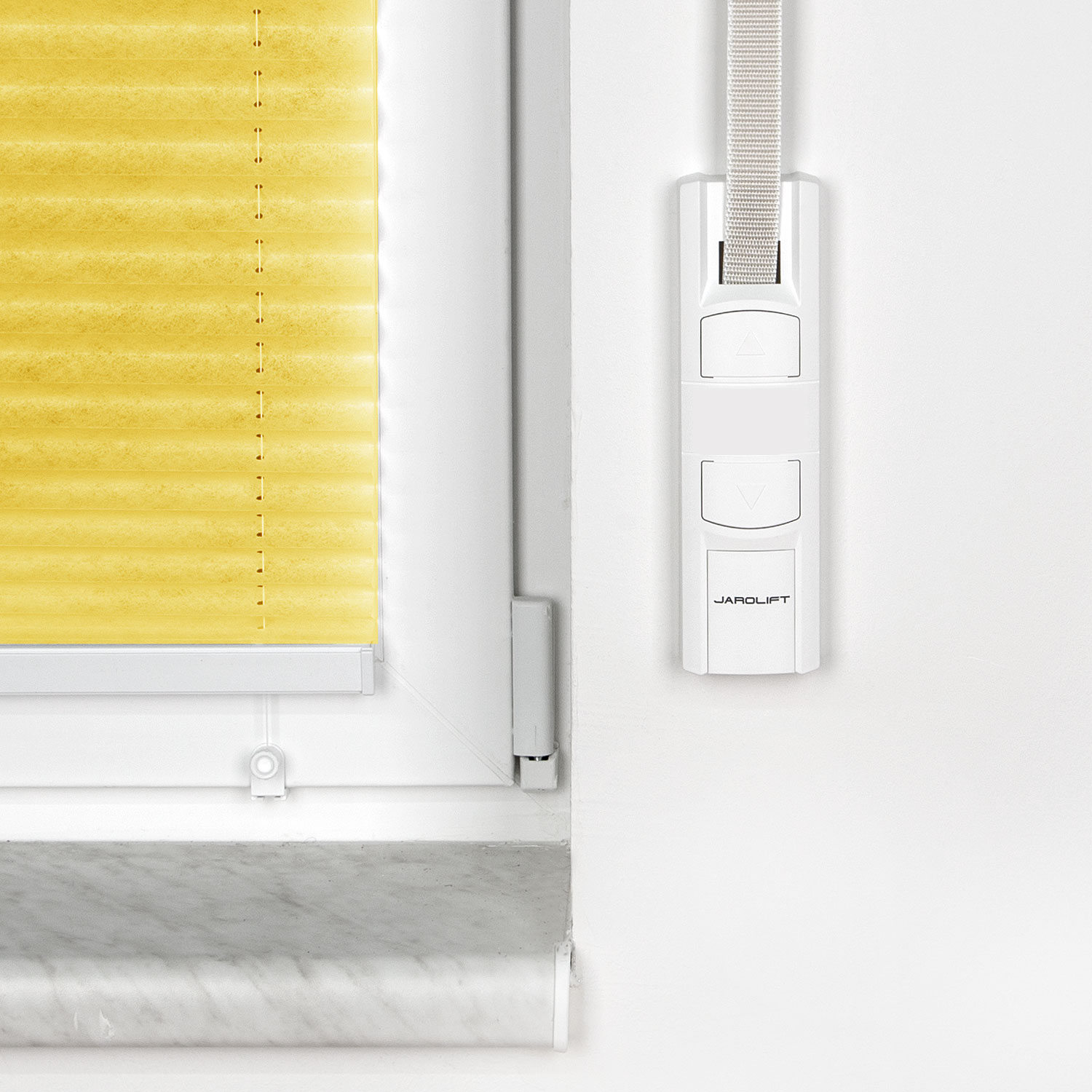 Elektrischer Gurtwickler an der Wand neben einem Fenster mit heruntergelassenem Rollo