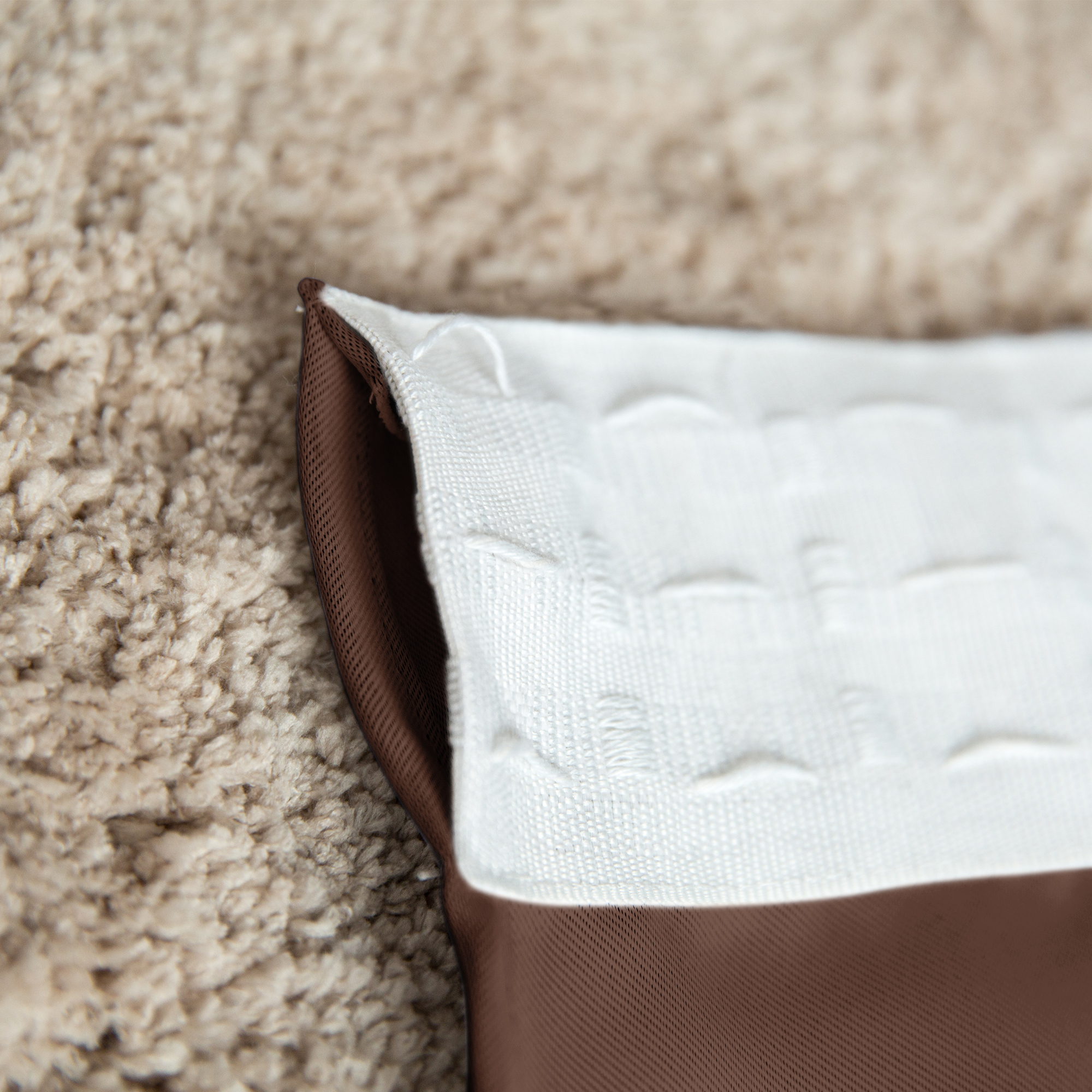 Nahaufnahme eines Vorhangs mit Kräuselband auf einem Teppichboden