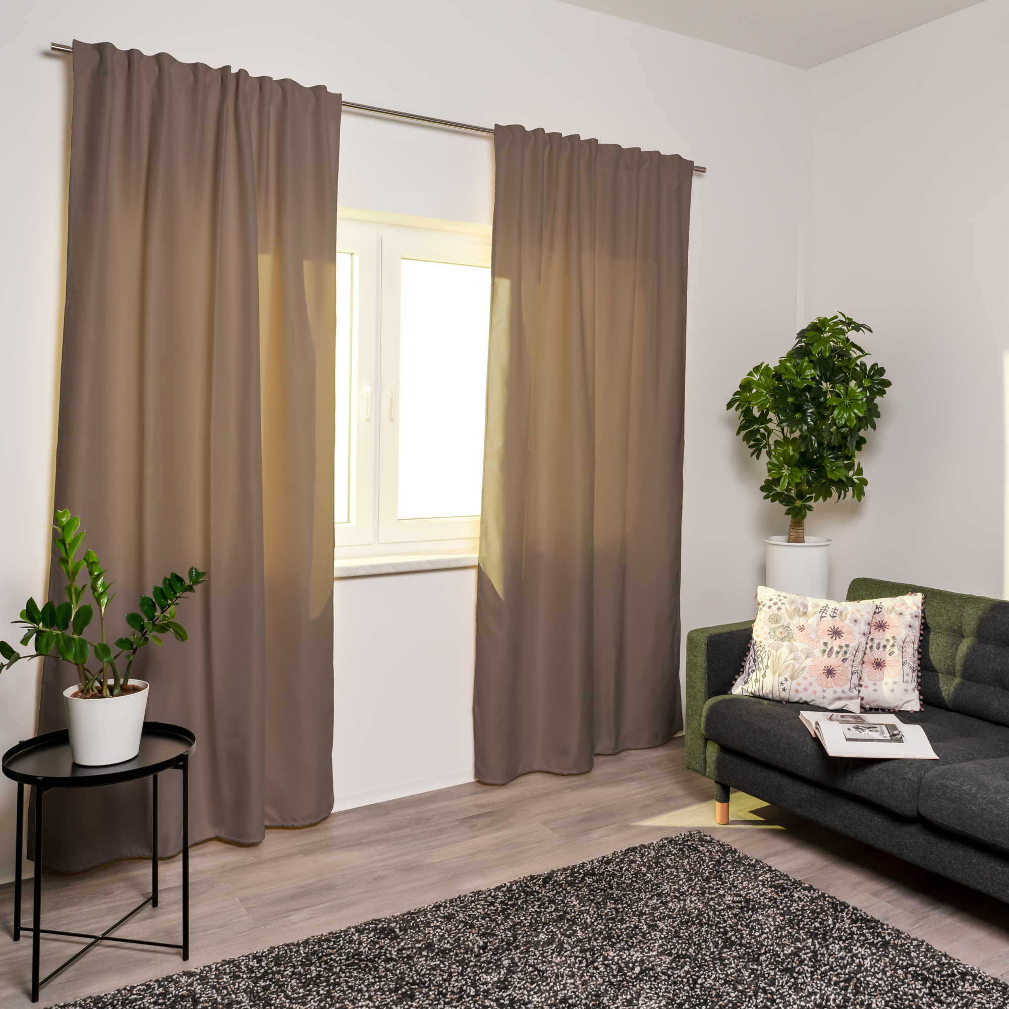 Thermo-Vorhang mit Kombiband an Fenster in modernem Wohnzimmer mit Pflanzen und Sofa