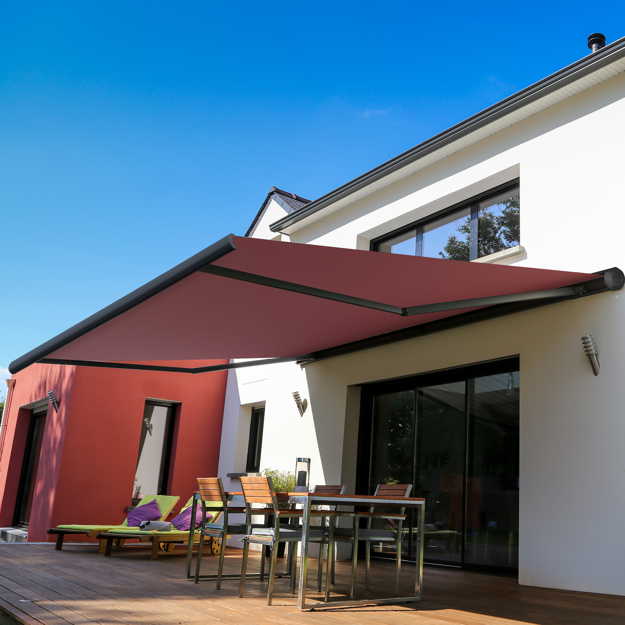 Kassettenmarkise an Hauswand über Terrasse mit Sitzmöbeln und Pflanzen
