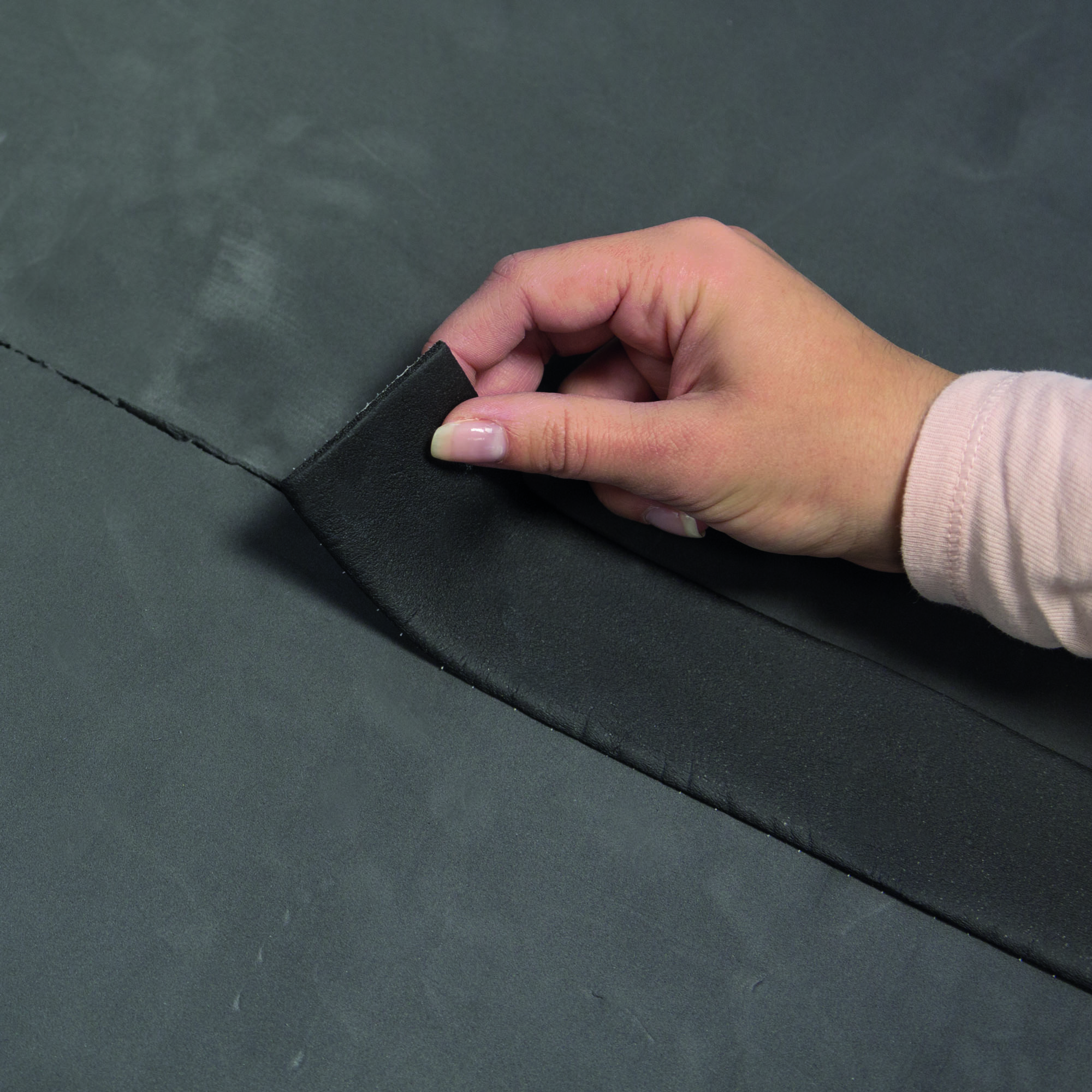 slider_image_d3147839f0284c43a291d32d1bc82973 Hand zieht Klebeband von Isoliermatte ab