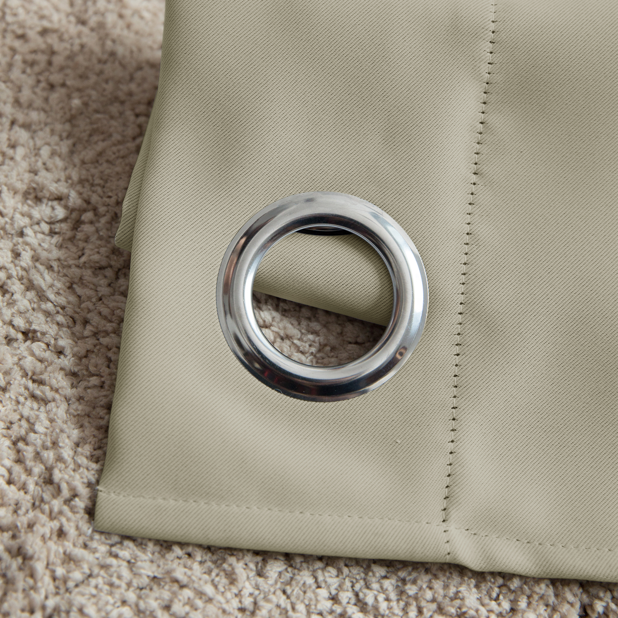 Ösenvorhang mit Metallring auf Teppich liegend