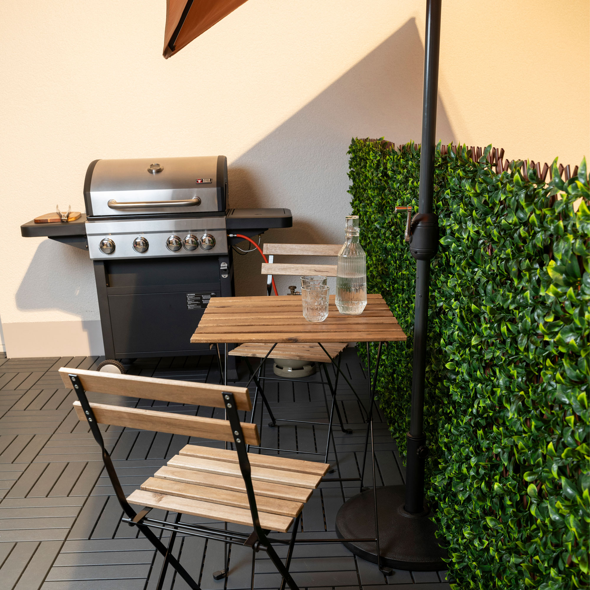 slider_image_018f104d2e017938ada07056d64abd80 Halbrunder Schirmständer neben Tisch und Grill auf Terrasse mit Sichtschutzwand