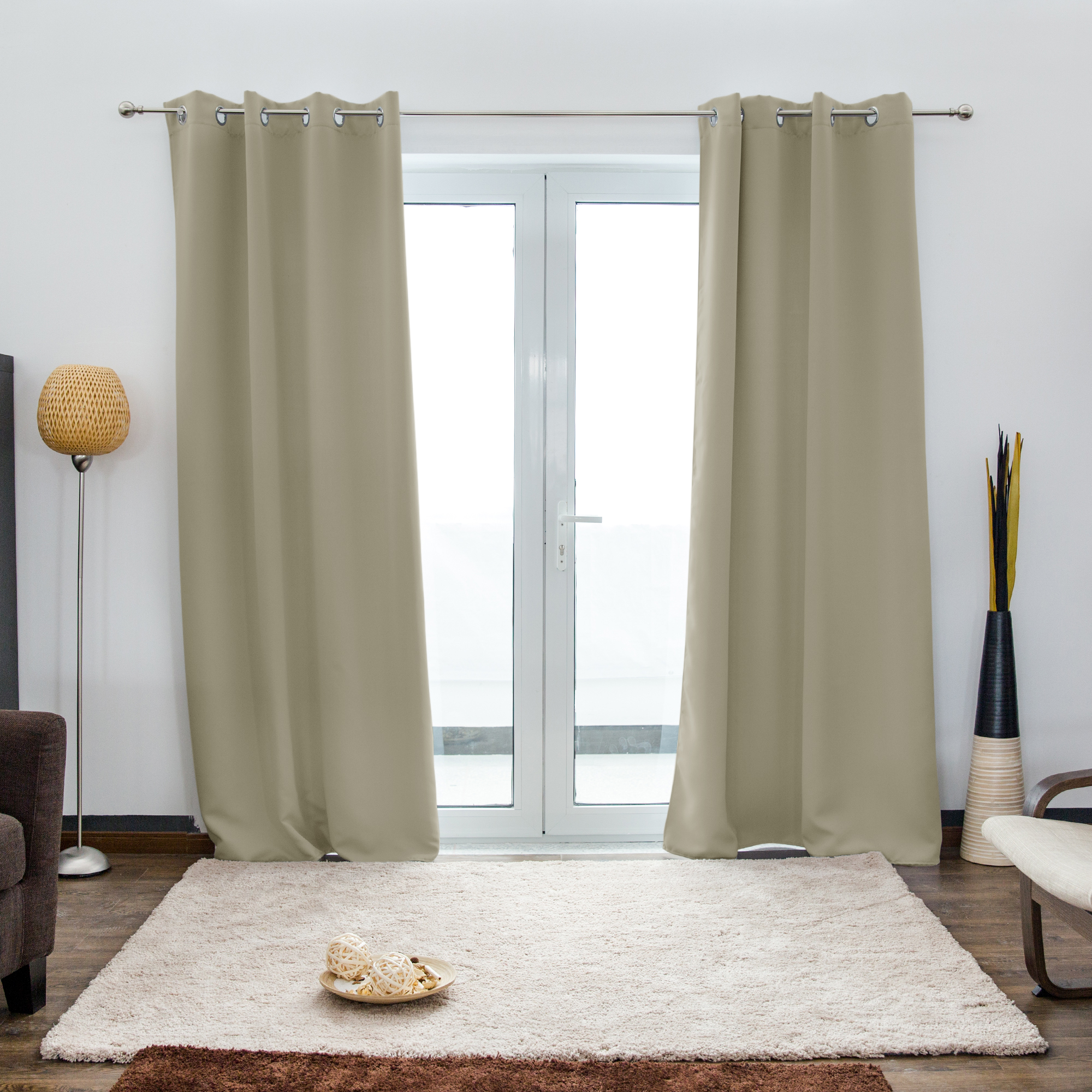 Ösenvorhang vor einer Glastür in einem Wohnzimmer mit Teppich und Stehlampe