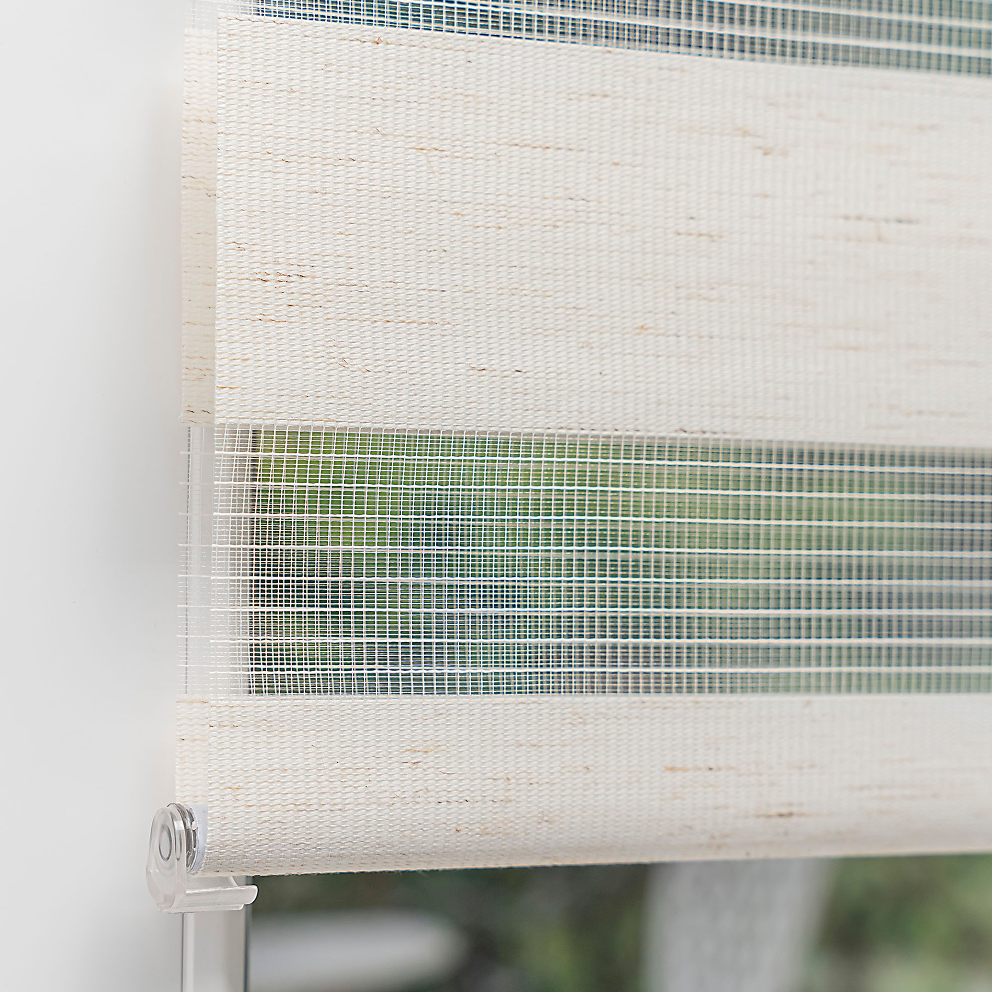 slider_image_926ebb0c21e14dbaaeb9e1d319d96b58 Klemmfix Doppelrollo an einem Fenster montiert, zeigt abwechselnde Streifen für Lichtregulierung