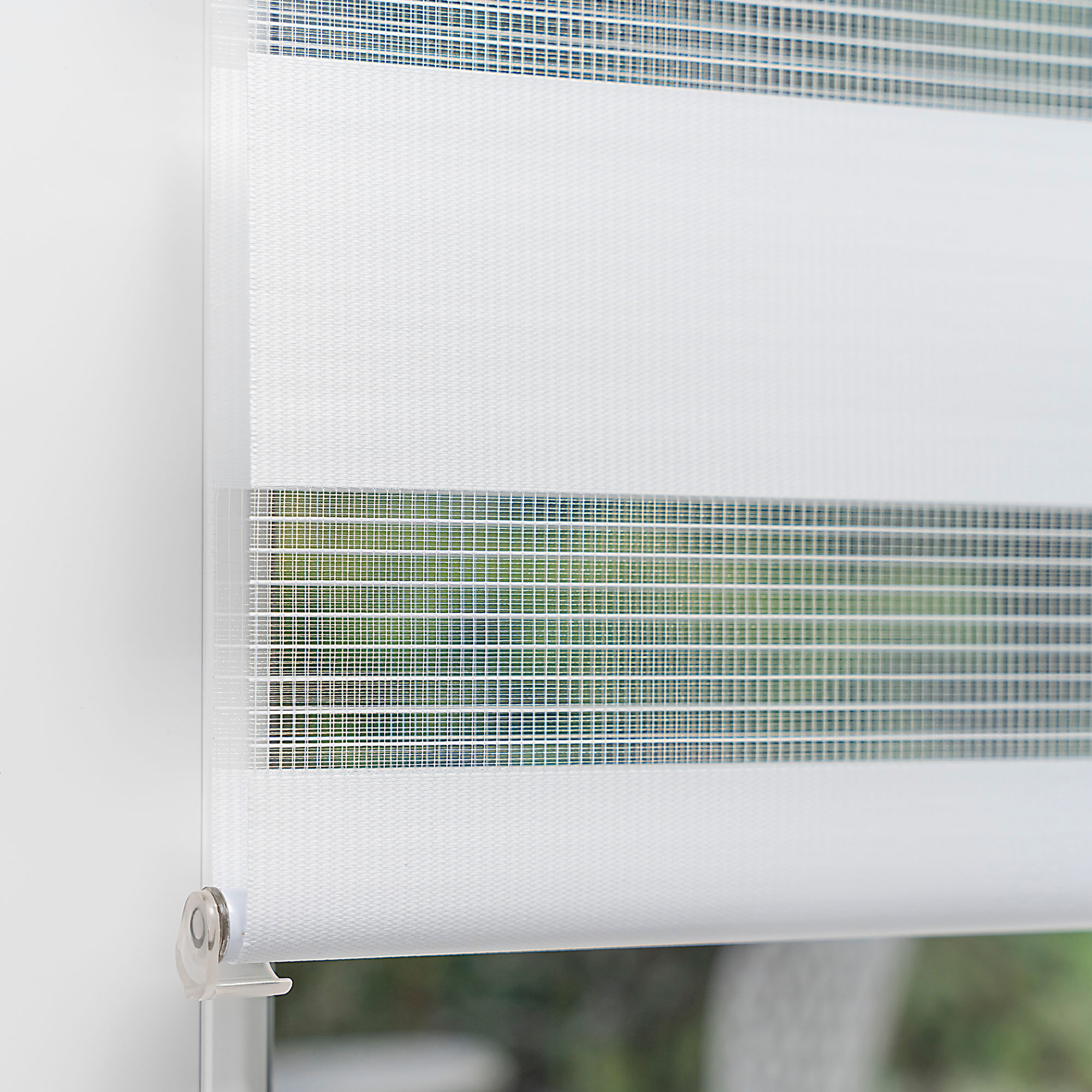 Klemmfix Doppelrollo an einem Fenster montiert, zeigt abwechselnde Streifen für Lichtregulierung