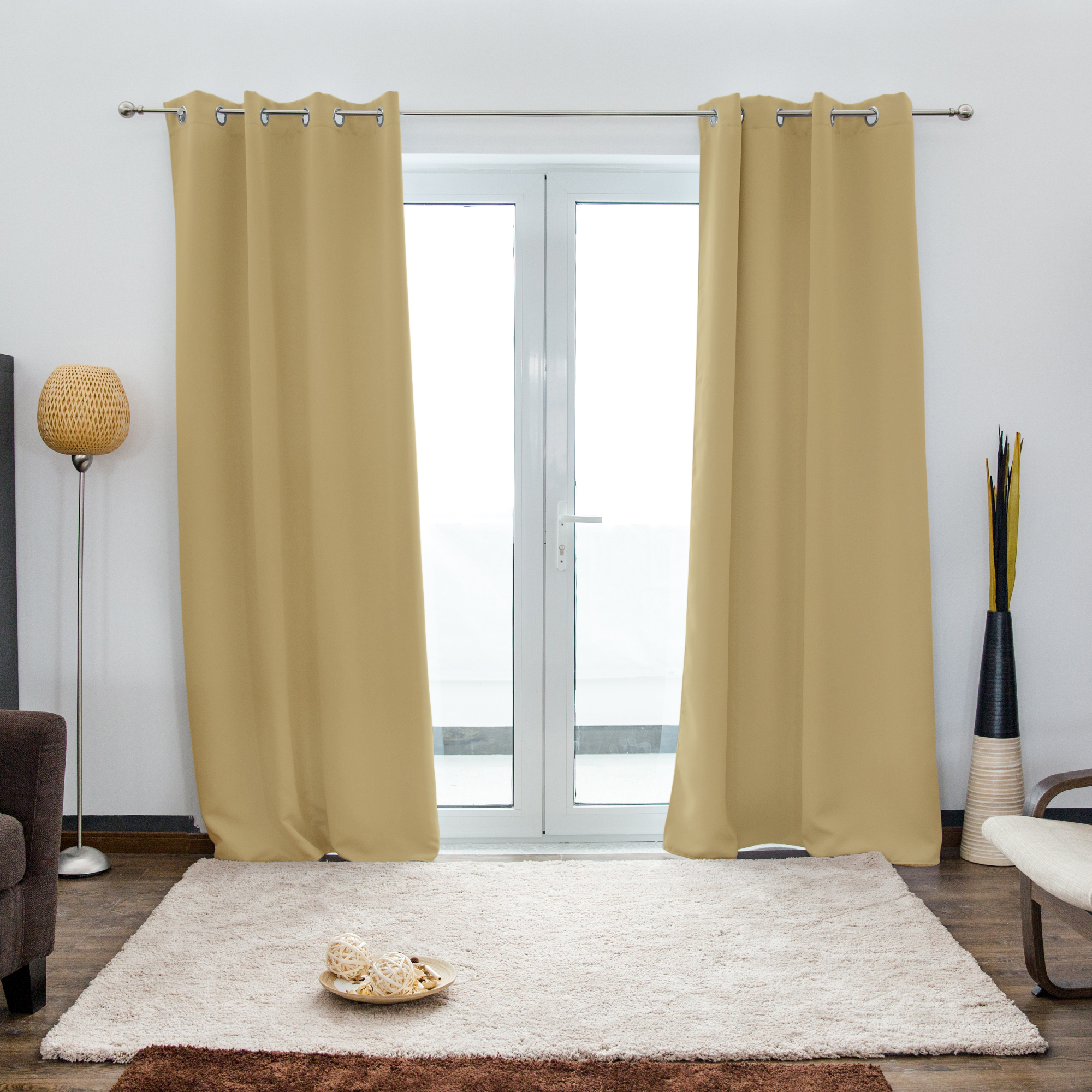 Ösenvorhang vor einer Glastür in einem Wohnzimmer mit Teppich und Stehlampe