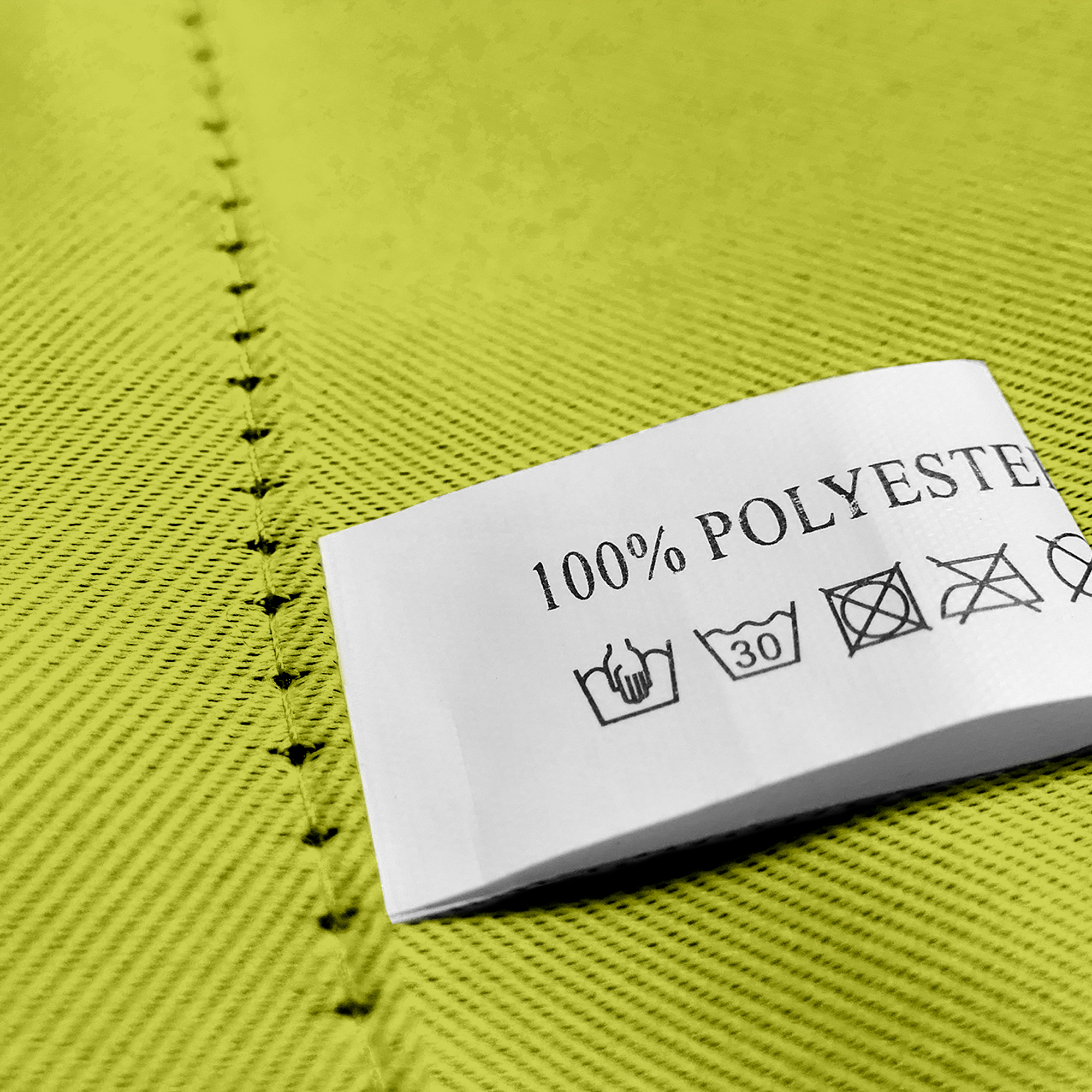 Nahaufnahme eines Stoffes mit Öse und Pflegeetikett aus 100% Polyester