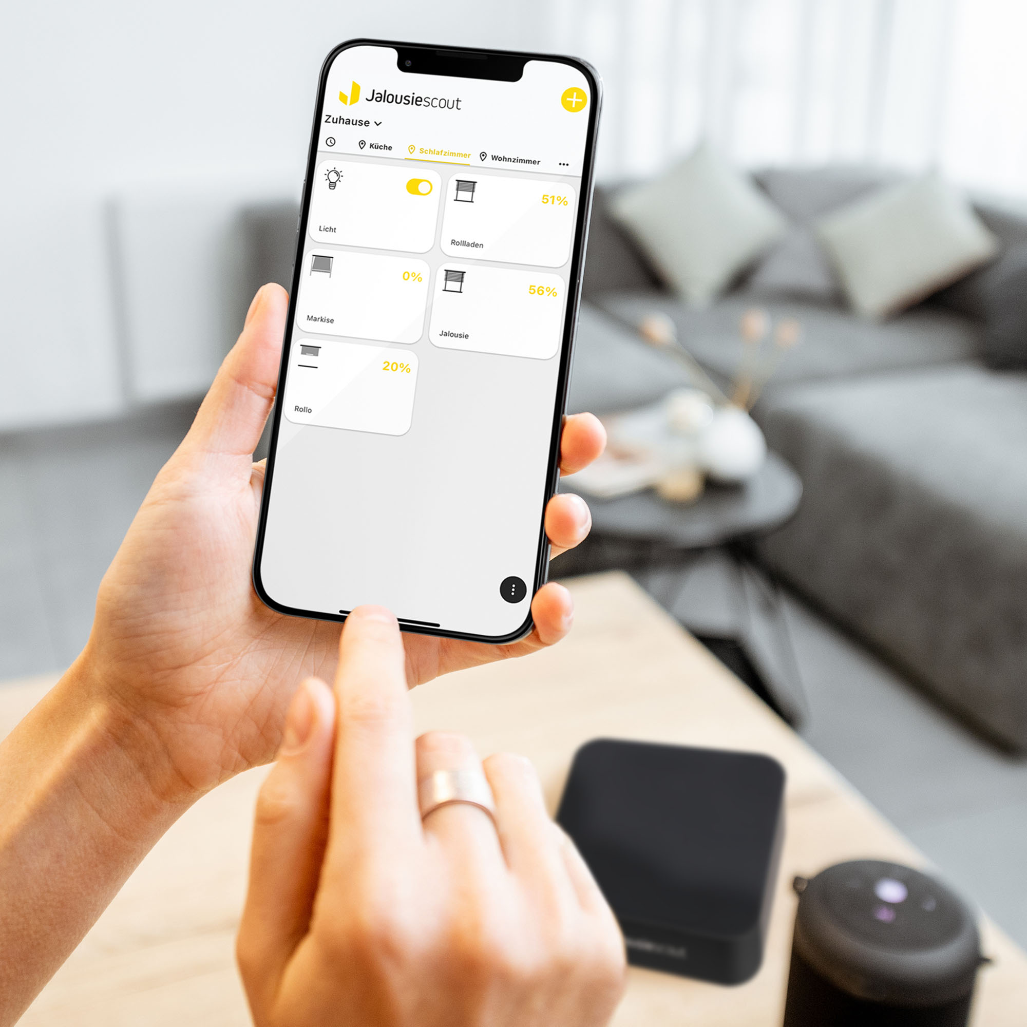 Person steuert Smart-Home-Geräte mit Smartphone-App im Wohnzimmer