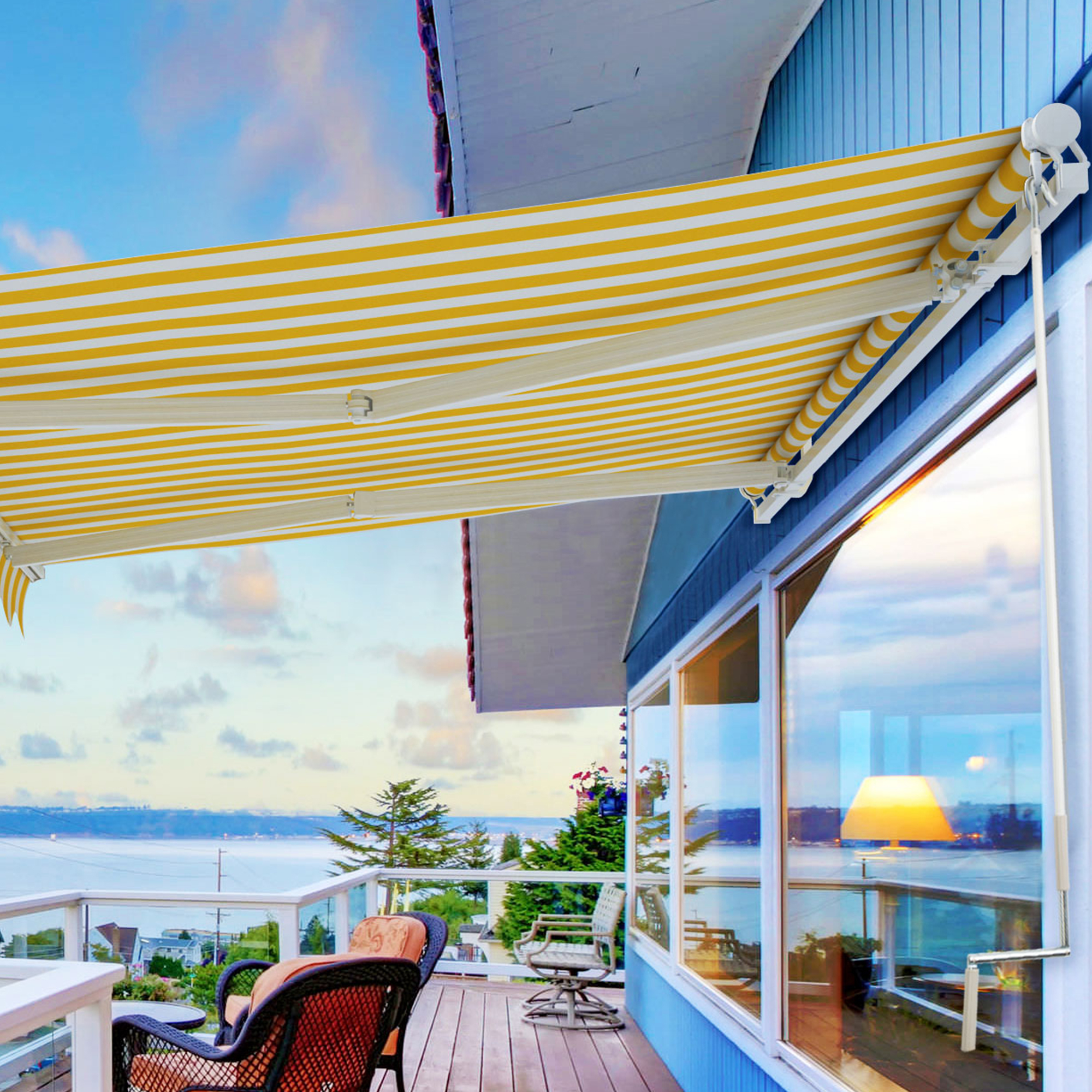 Terrasse mit ausgefahrener Markise, Blick auf Meer und Häuser im Hintergrund