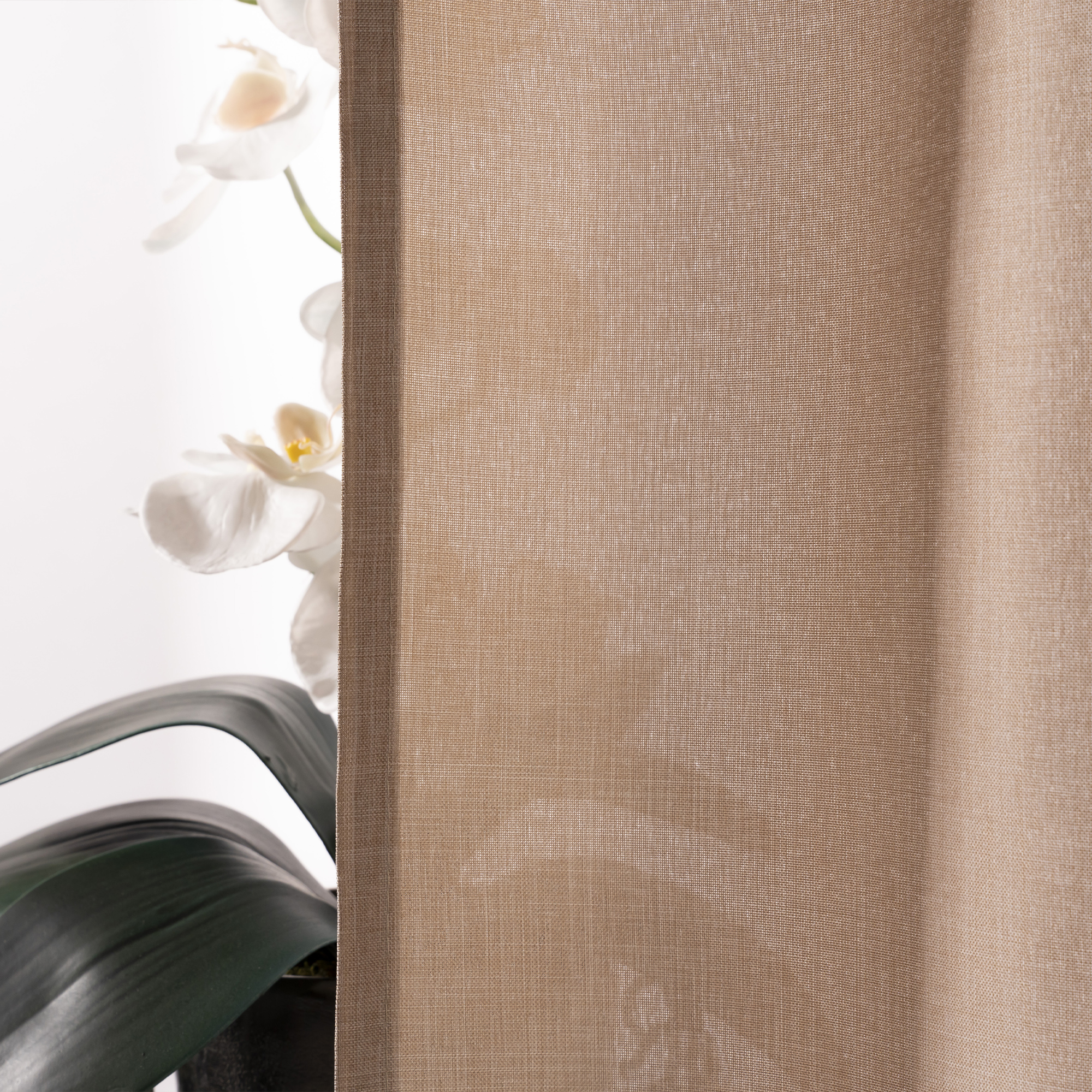 Vorhangdetail mit transparentem Stoff, im Hintergrund eine Pflanze mit Blüten