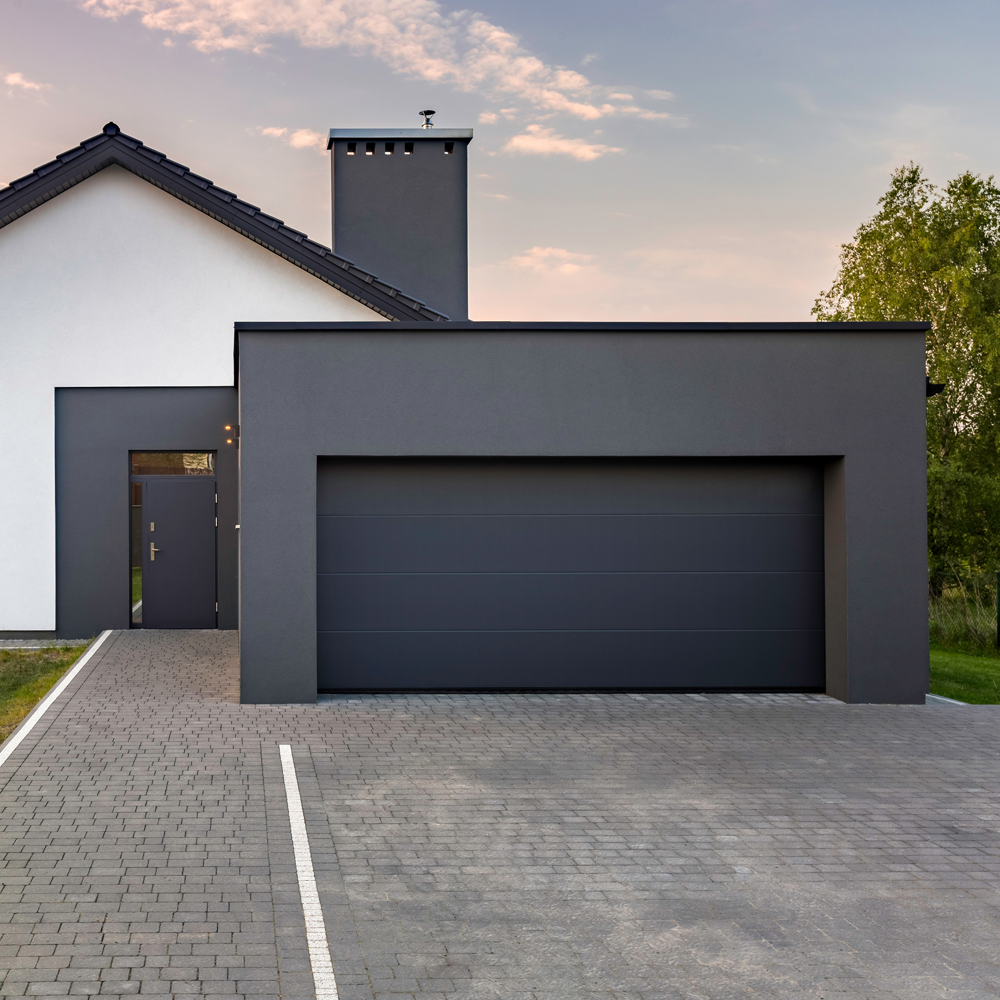 Modernes Haus mit großer Garage und gepflasterter Einfahrt