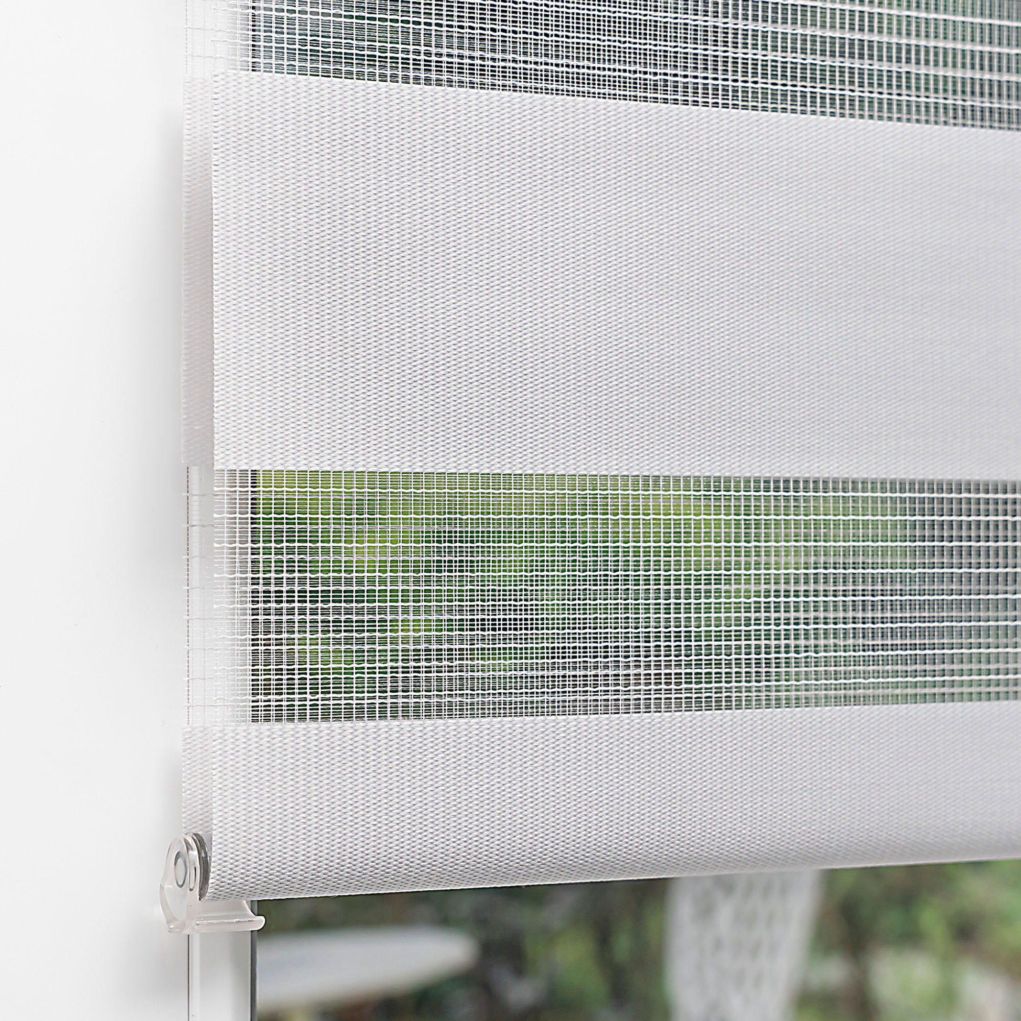 Klemmfix Doppelrollo an einem Fenster montiert, zeigt abwechselnde Streifen für Lichtregulierung