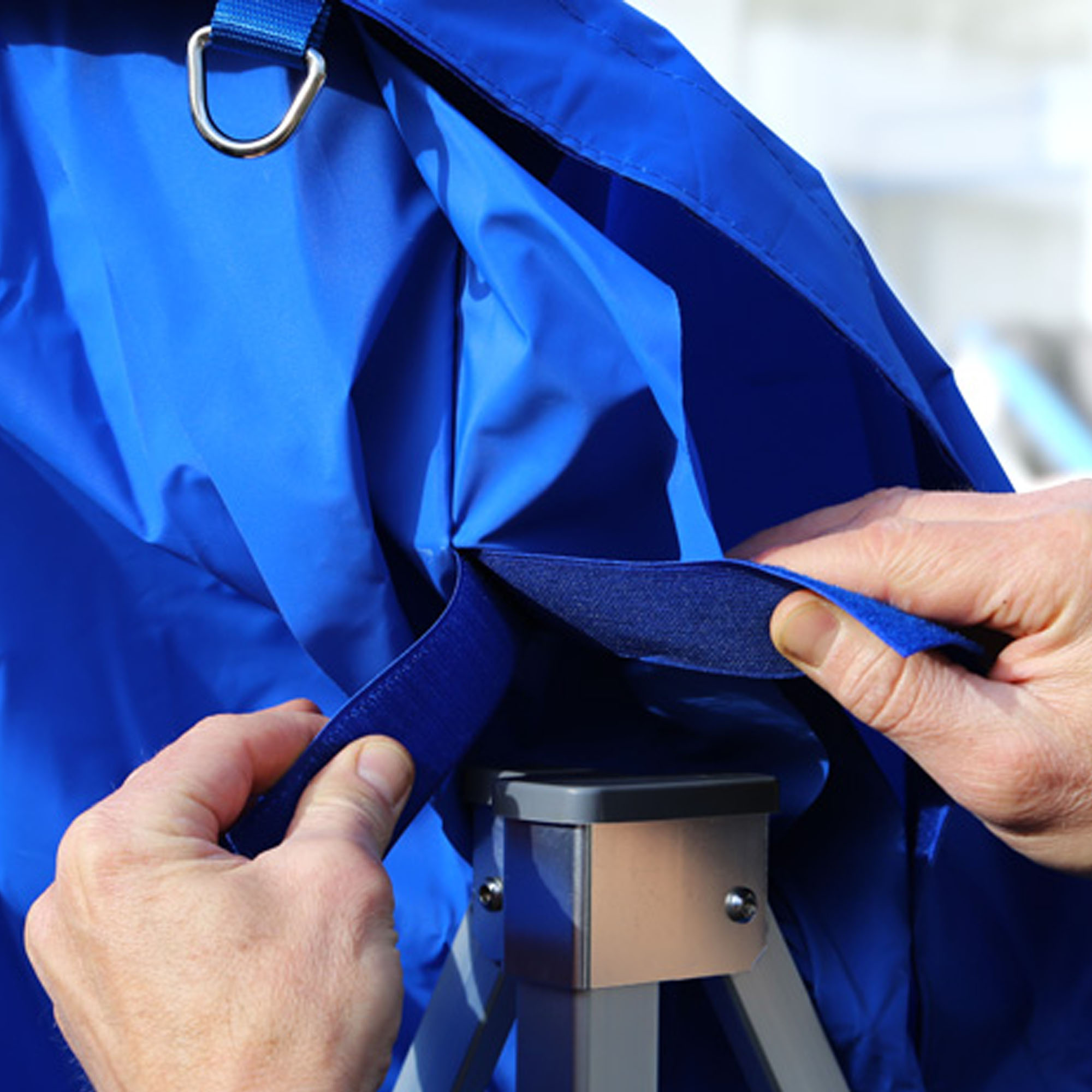 slider_image_01910d9ec4b1742da9c33921a53d3165 Person befestigt Dach an Faltpavillon mit Klettverschluss und Metallring