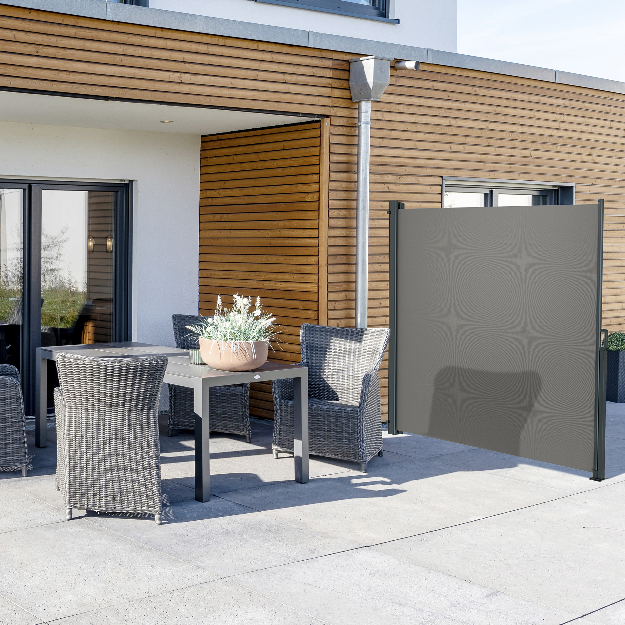 Seitenzugmarkise neben Terrasse mit Tisch und Stühlen, bietet Sicht- und Windschutz