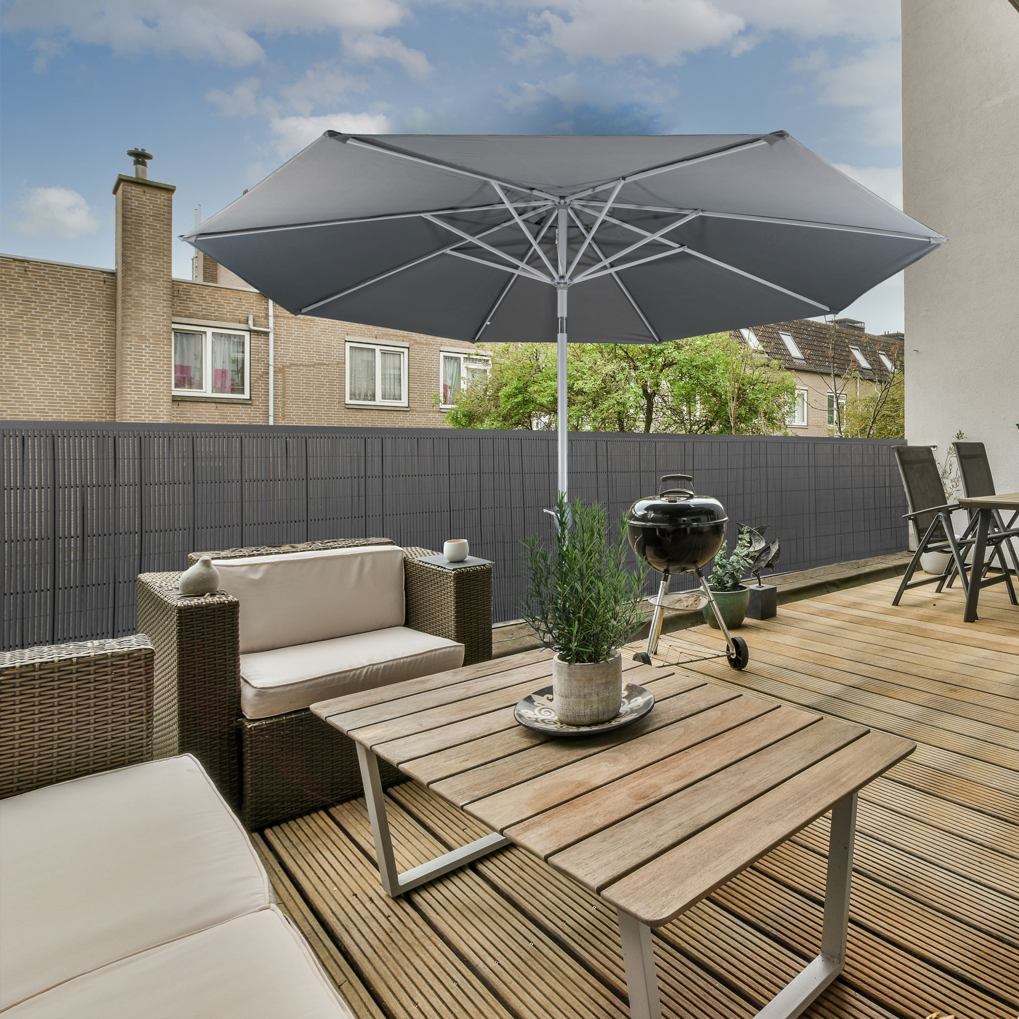 Terrasse mit Sichtschutzmatte aus Bambus, Gartenmöbeln und Sonnenschirm