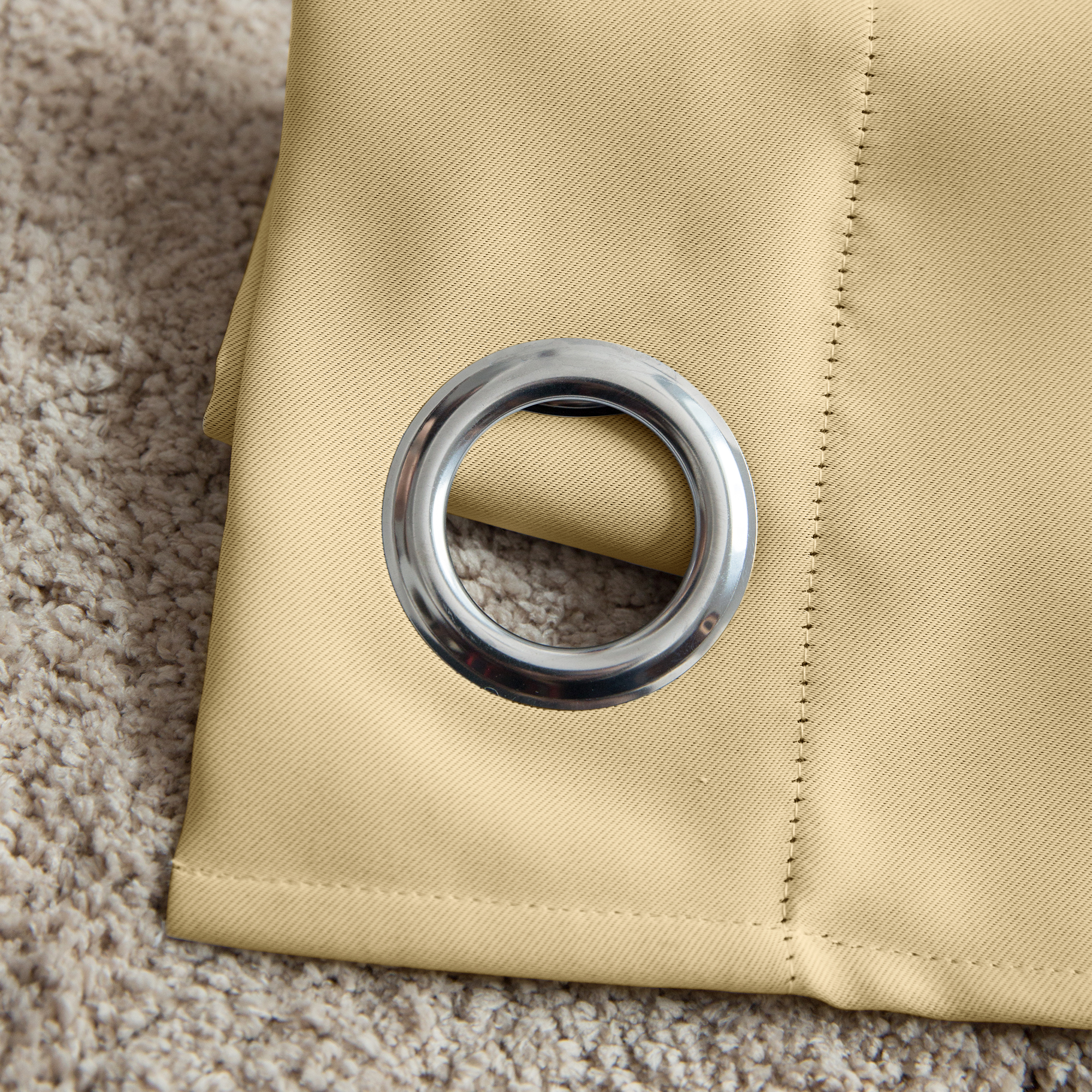 Ösenvorhang mit Metallring auf Teppich liegend