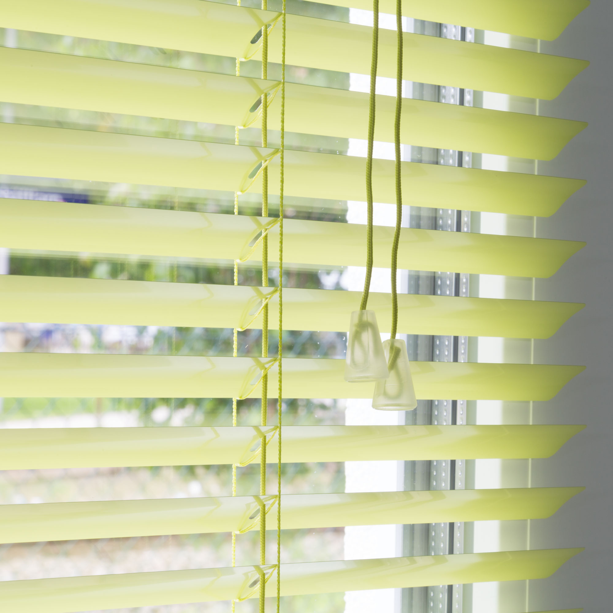 Aluminium Jalousie mit Lamellen und Zugkordel vor einem Fenster