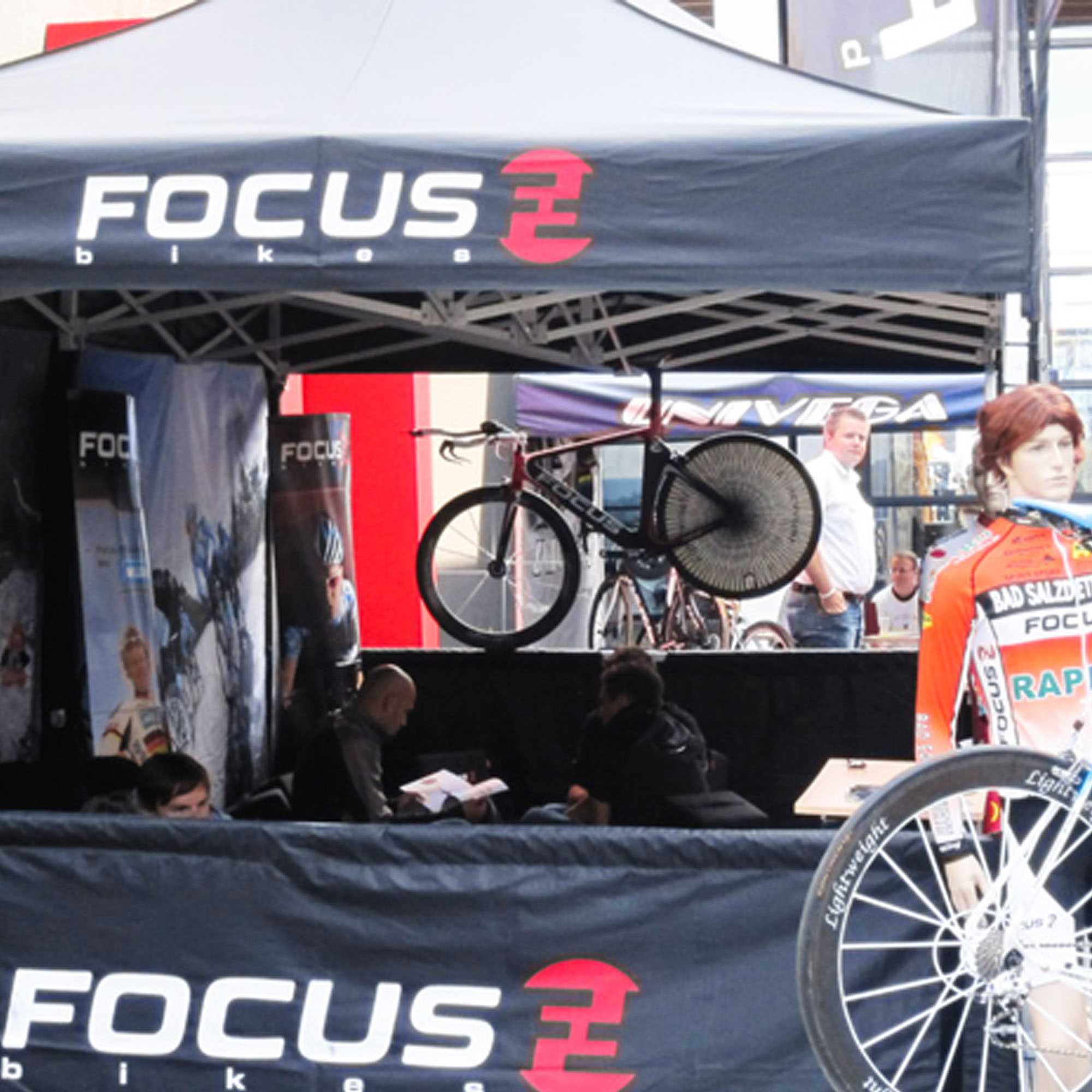 Gestell für Faltpavillon PRO mit Fahrrad und Personen im Hintergrund