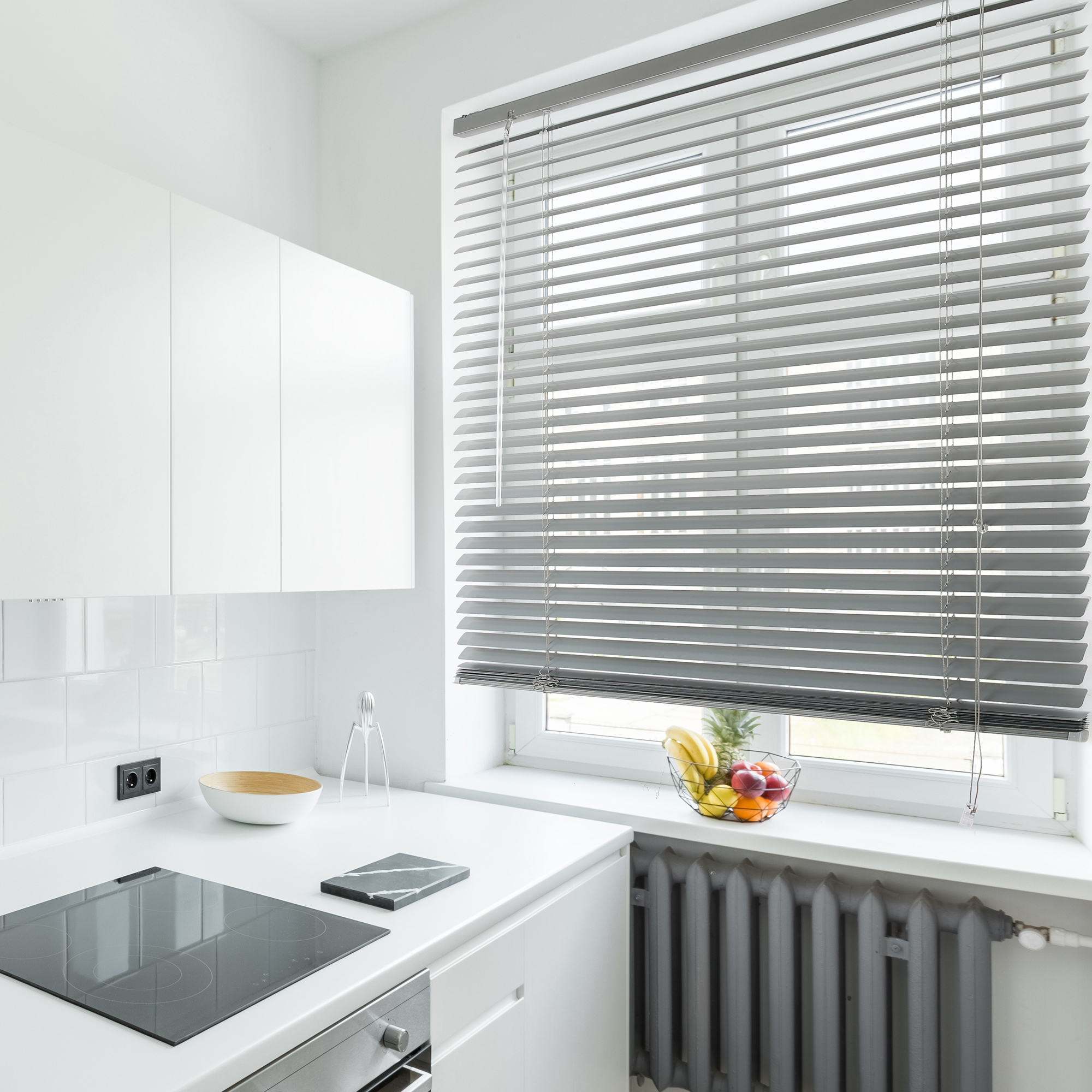 slider_image_0f1bed6c09af419a8e53cbaa1bd592fd Aluminium Jalousie an einem Fenster in einer modernen Küche mit weißen Schränken und Geräten